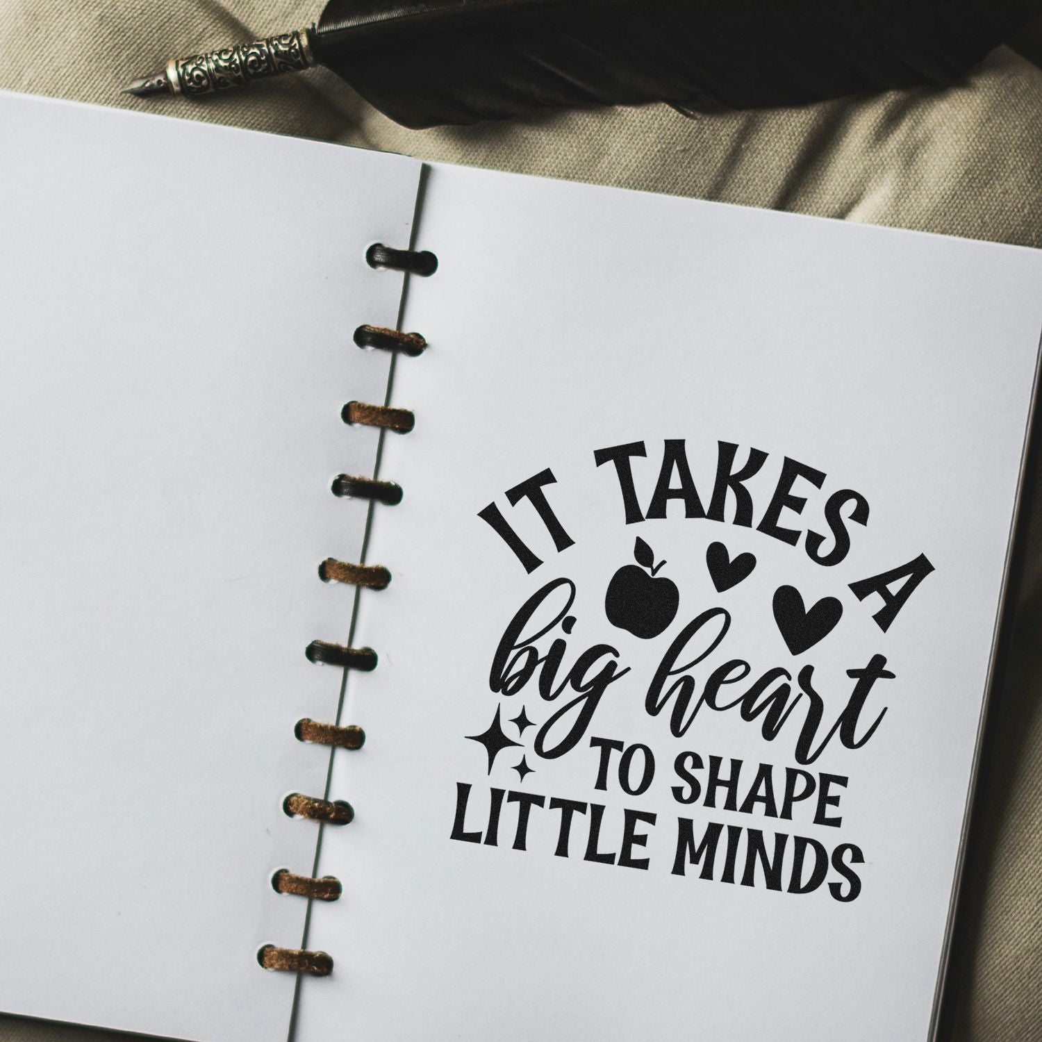 Teacher rubber stamp quote on notebook page: It takes a big heart to shape little minds in bold black lettering.