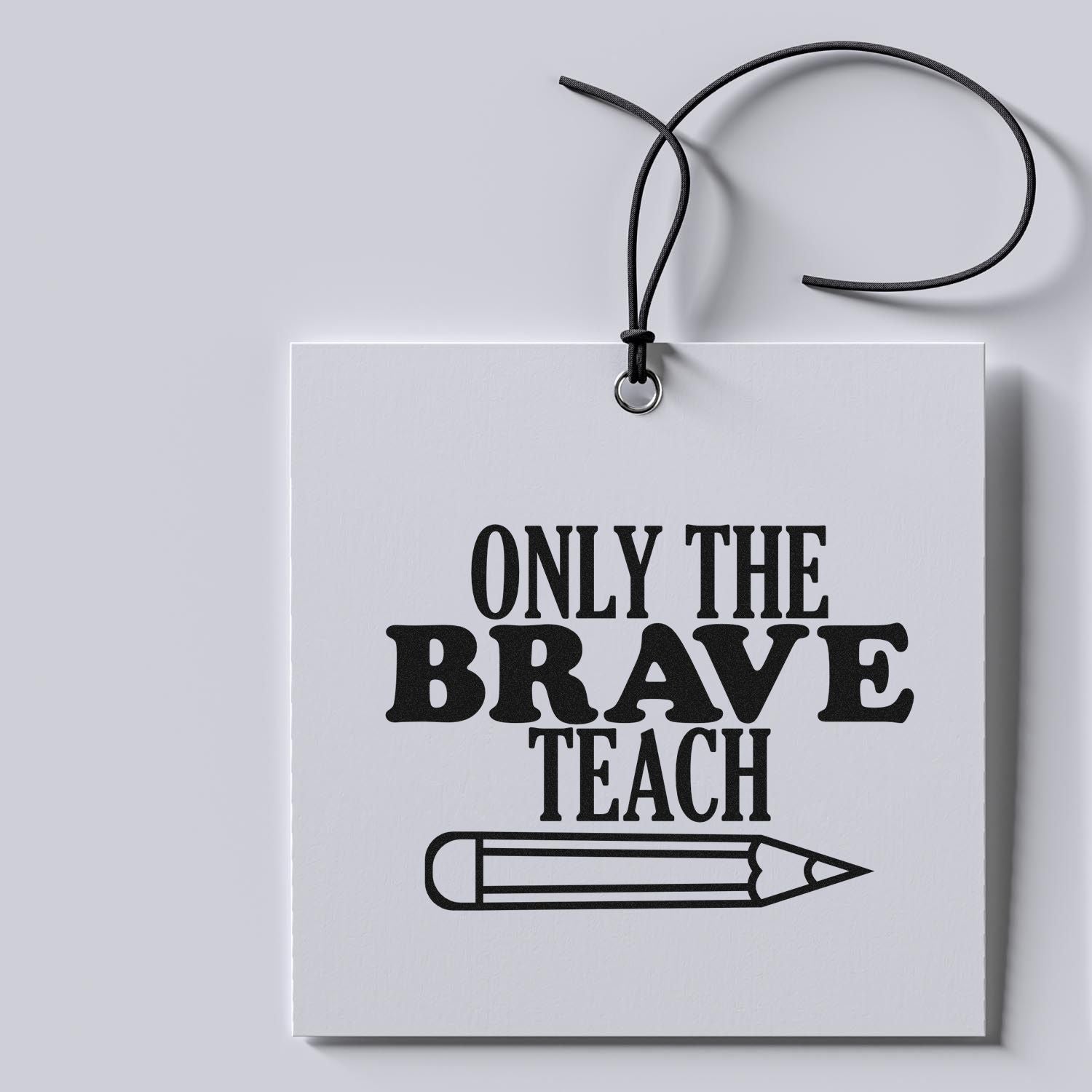 Teacher rubber stamp design on hanging gift tag reading Only the Brave Teach with pencil graphic.