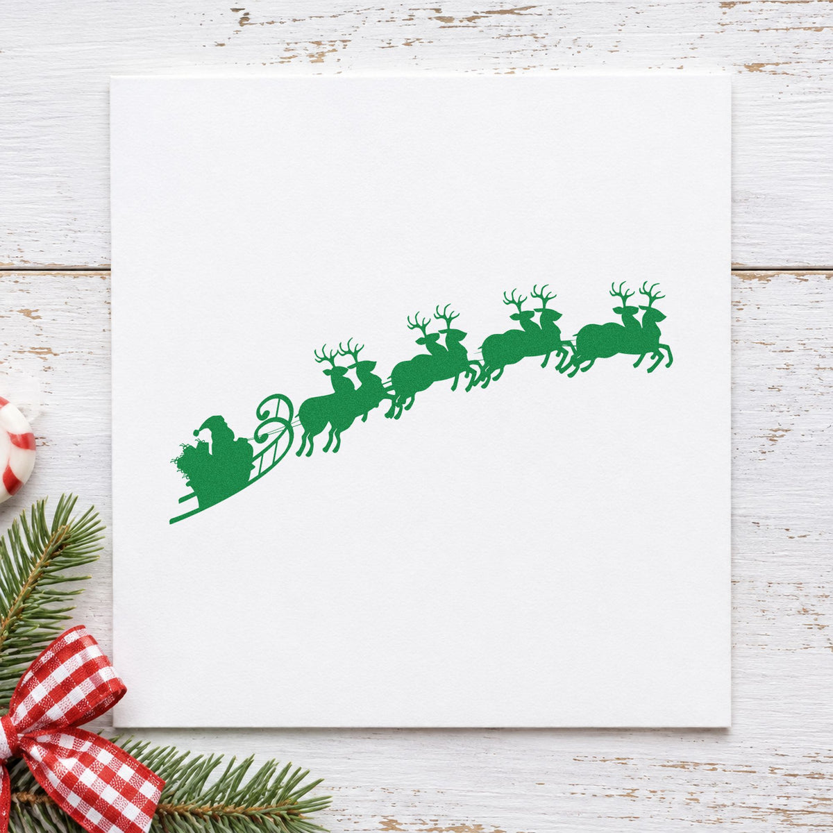 Santa Sleigh And Reindeer craft stamp imprint in green ink on a handmade project, one idea being route map pages.
