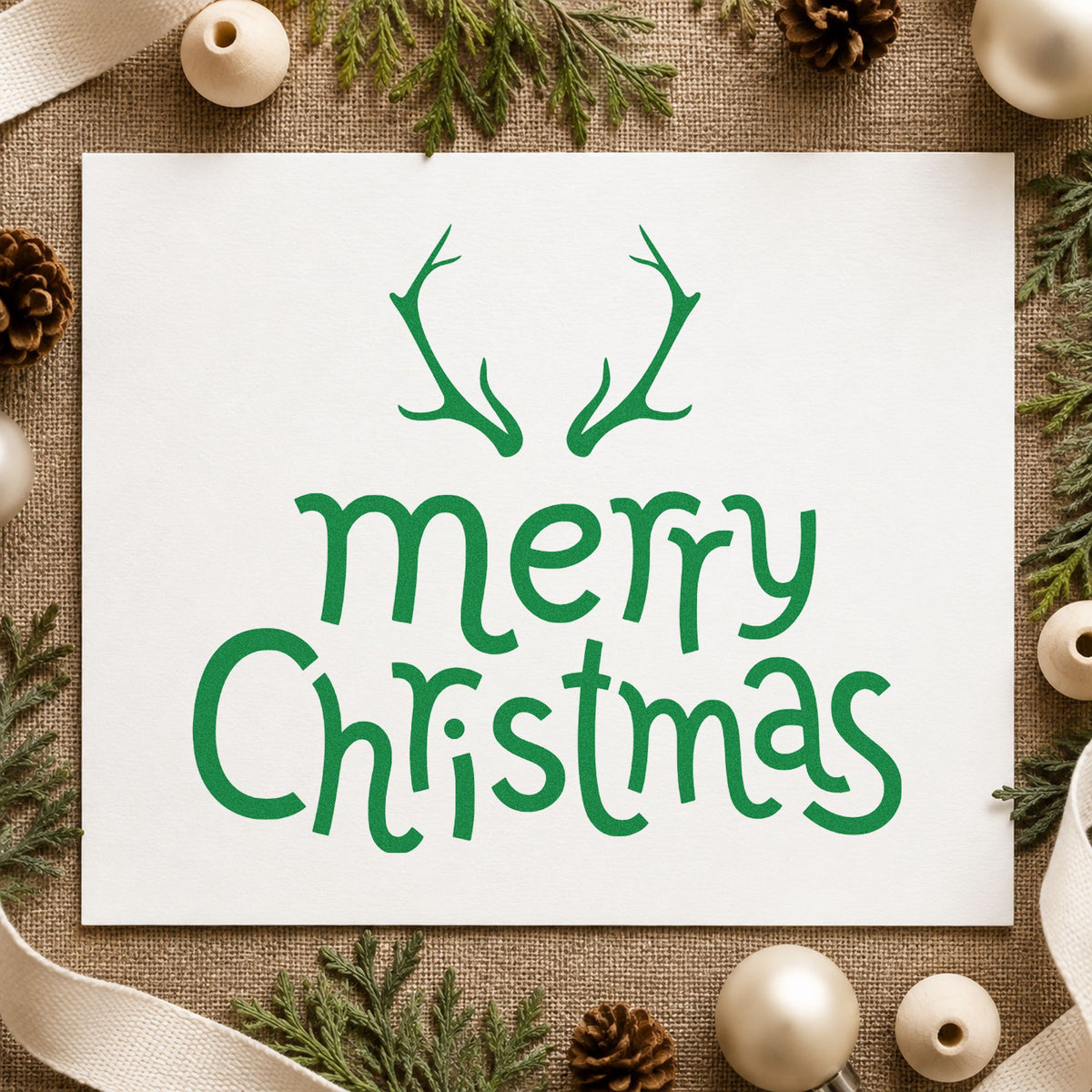 Merry Christmas Antlers craft stamp imprinted in green ink on paper, a design suited to framed cabin decor.
