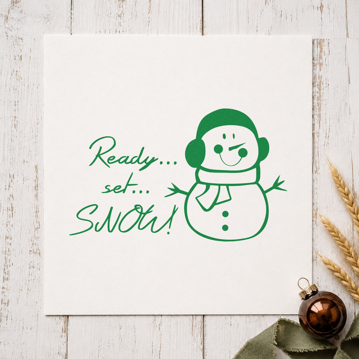 Ready Set Snow Snowman craft stamp imprint in green ink on a handmade project, one idea being field trip wristbands.