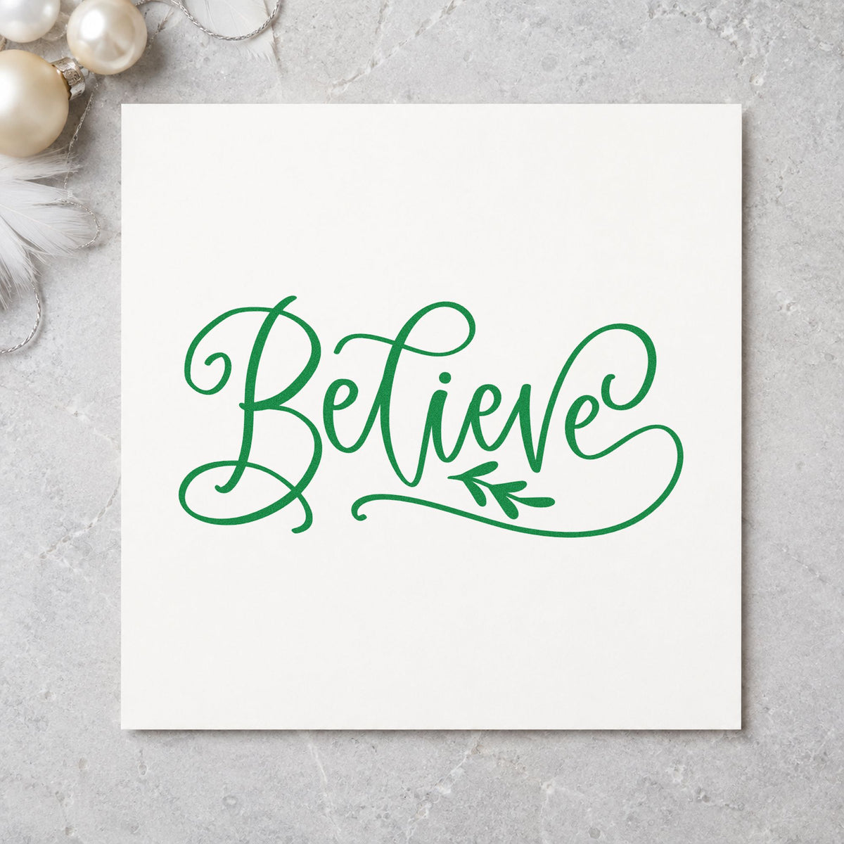 Believe With Leaf Flourish craft stamp imprint in green ink on a handmade project, one idea being silk ribbon tags.