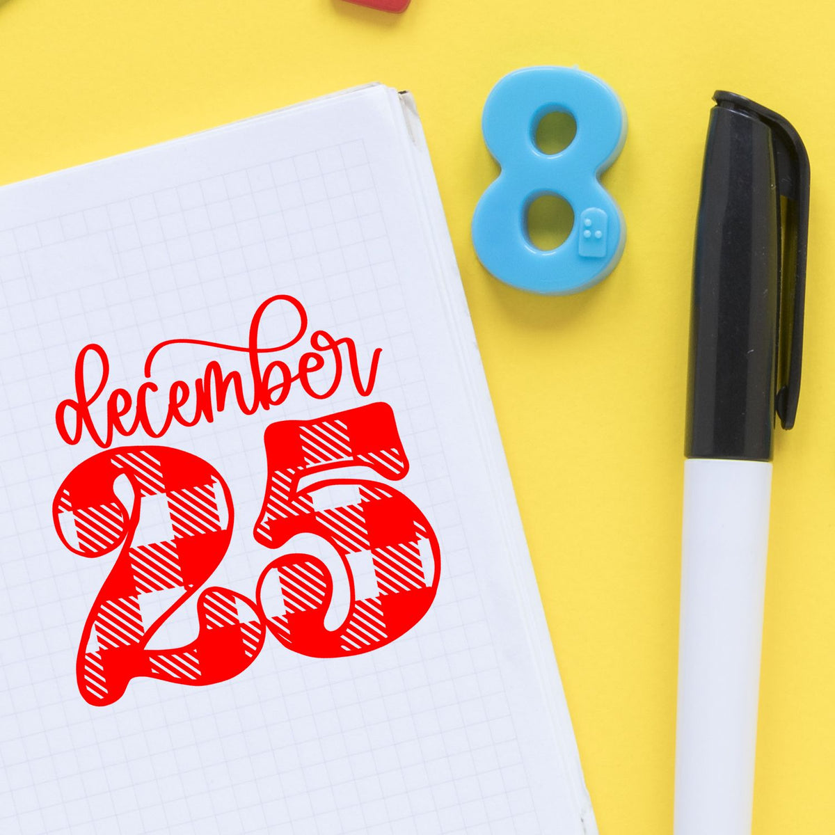 December Twenty Five Plaid rubber stamp shown in red ink, stamped for projects such as countdown album page.