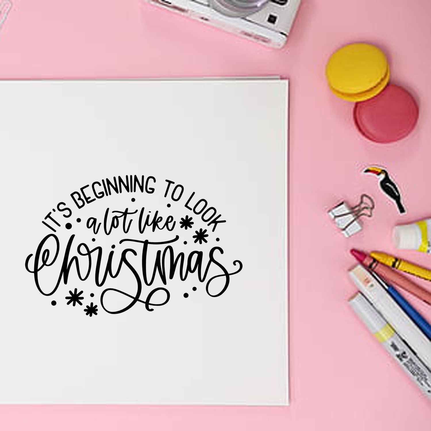 Christmas rubber stamp design on a notebook with craft supplies for holiday card making and festive DIY projects.