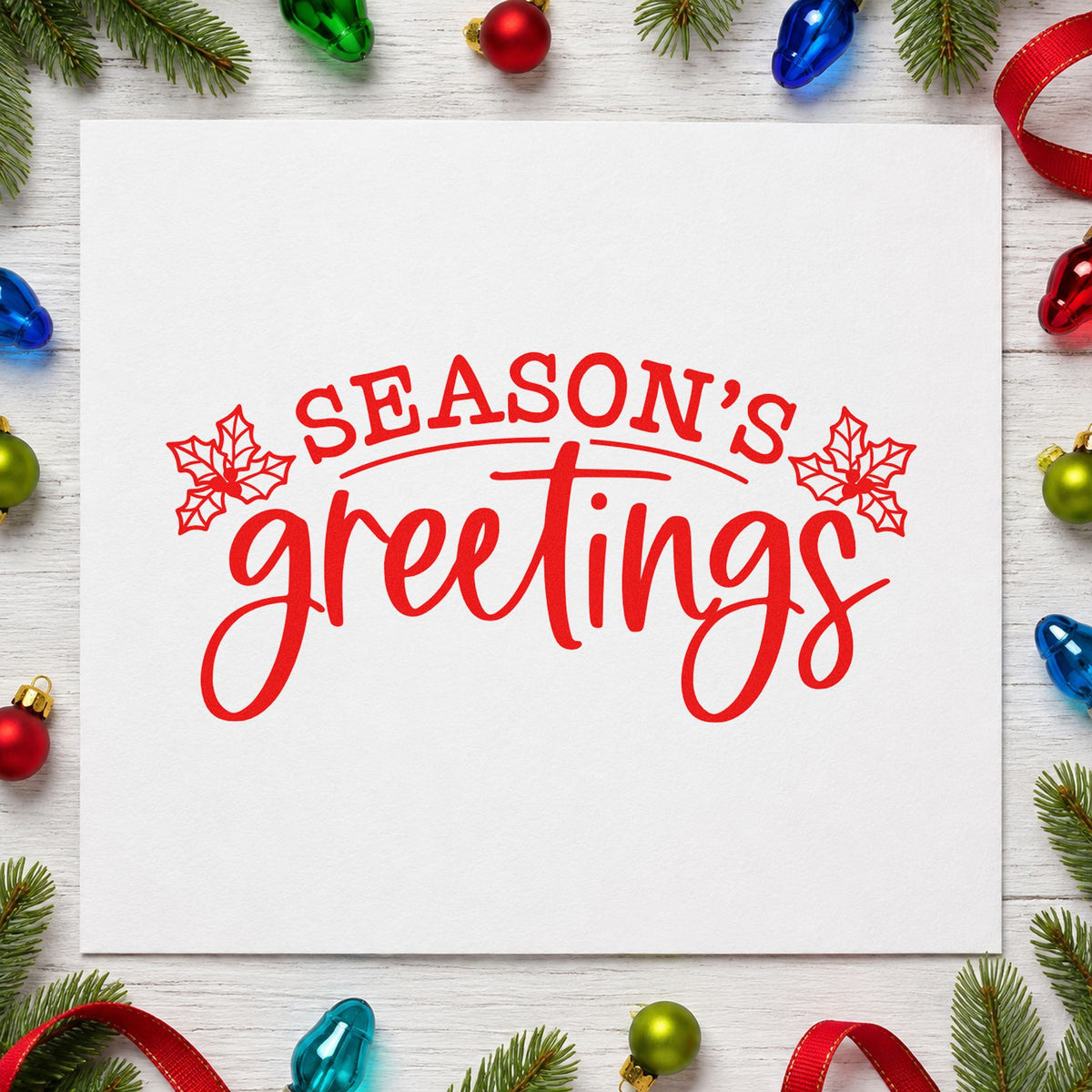 Season's Greetings Holly rubber stamp shown in red ink, stamped for projects such as paper ream labels.