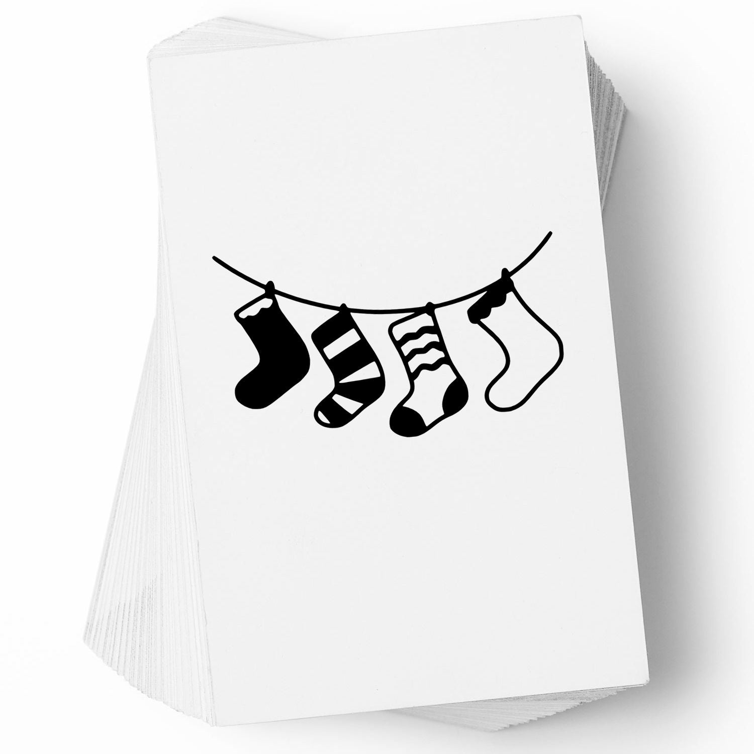 Rubber stamp design of four hanging socks on a clothesline, printed on stacked white cards.