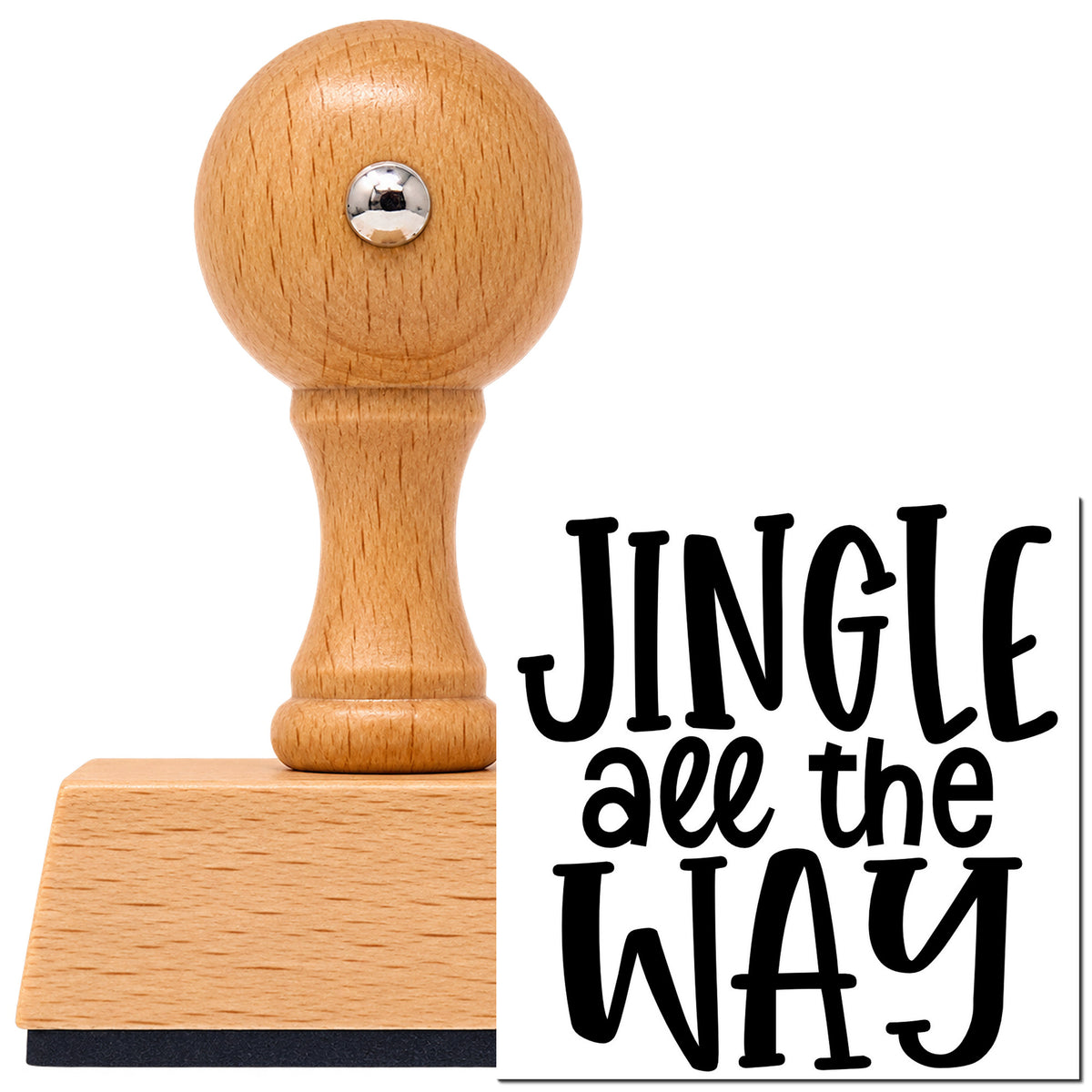 Jingle All The Way Lettering Vintage Pro rubber stamp in European beech wood with a round knob handle, shown beside its black imprint.