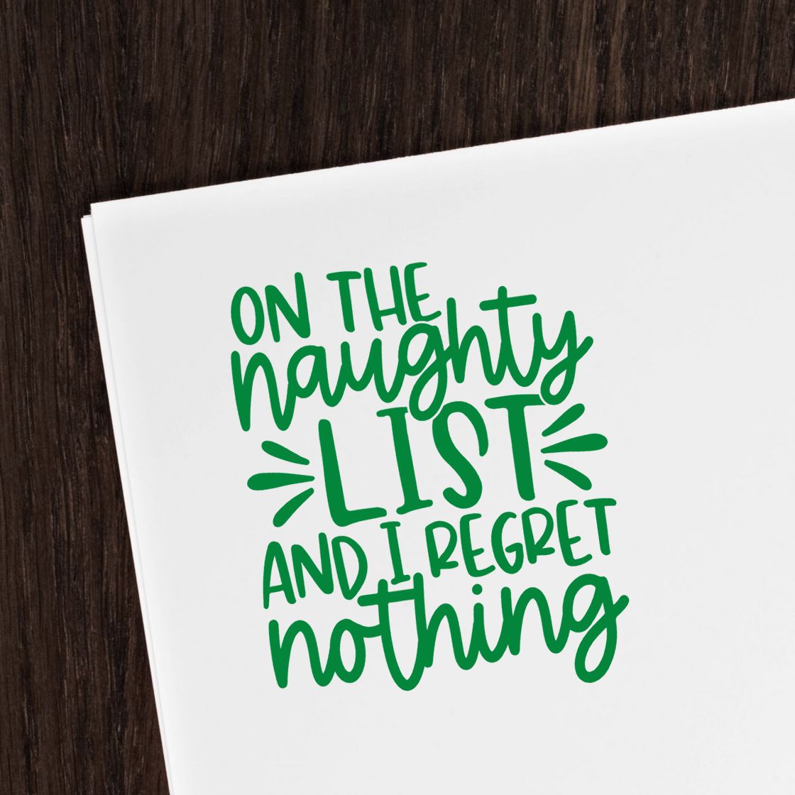 Naughty List Regret Nothing rubber stamp shown in green ink, stamped for projects such as mischief album page.