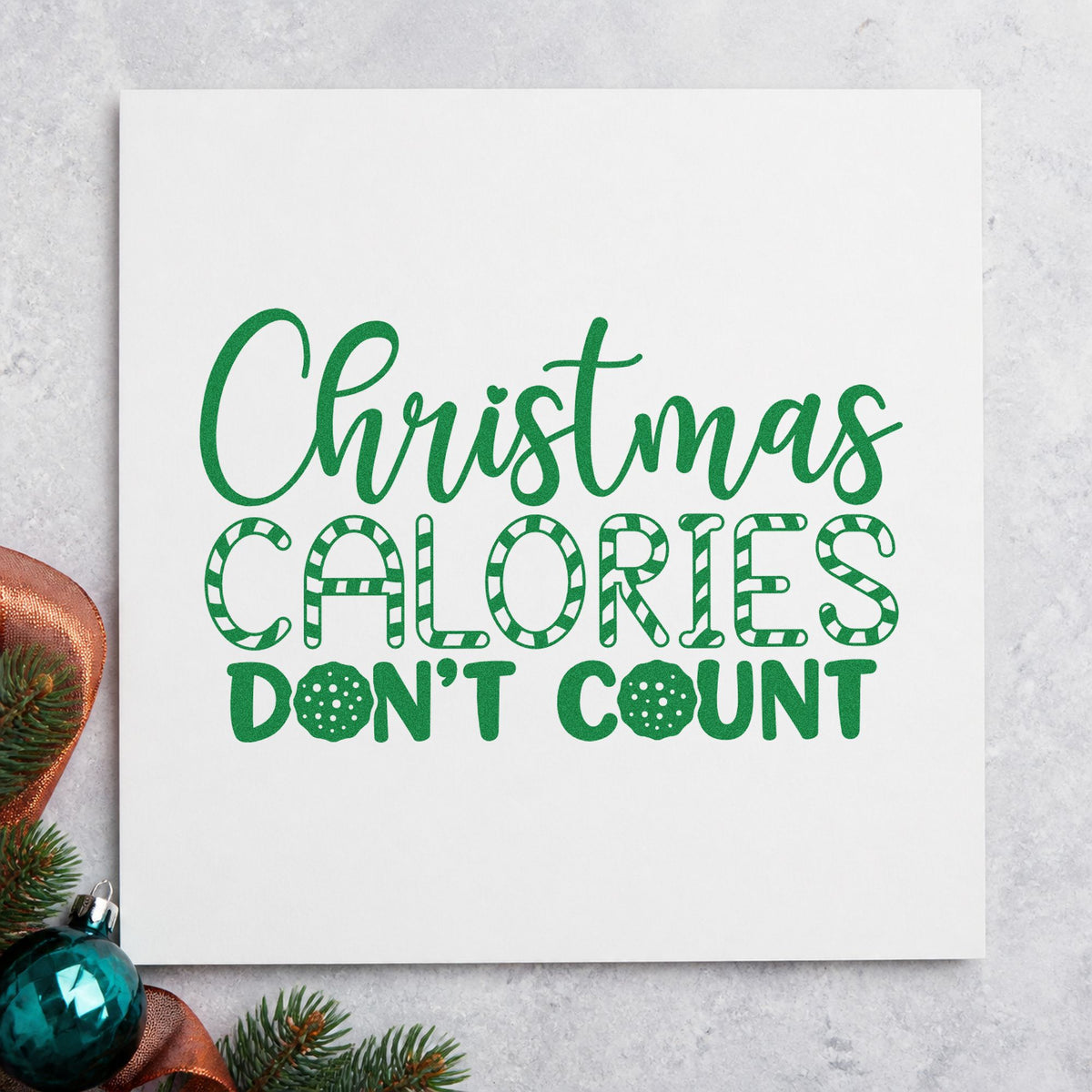 Christmas Calories Don't Count craft stamp imprint in green ink on a handmade project, one idea being protein bar tags.