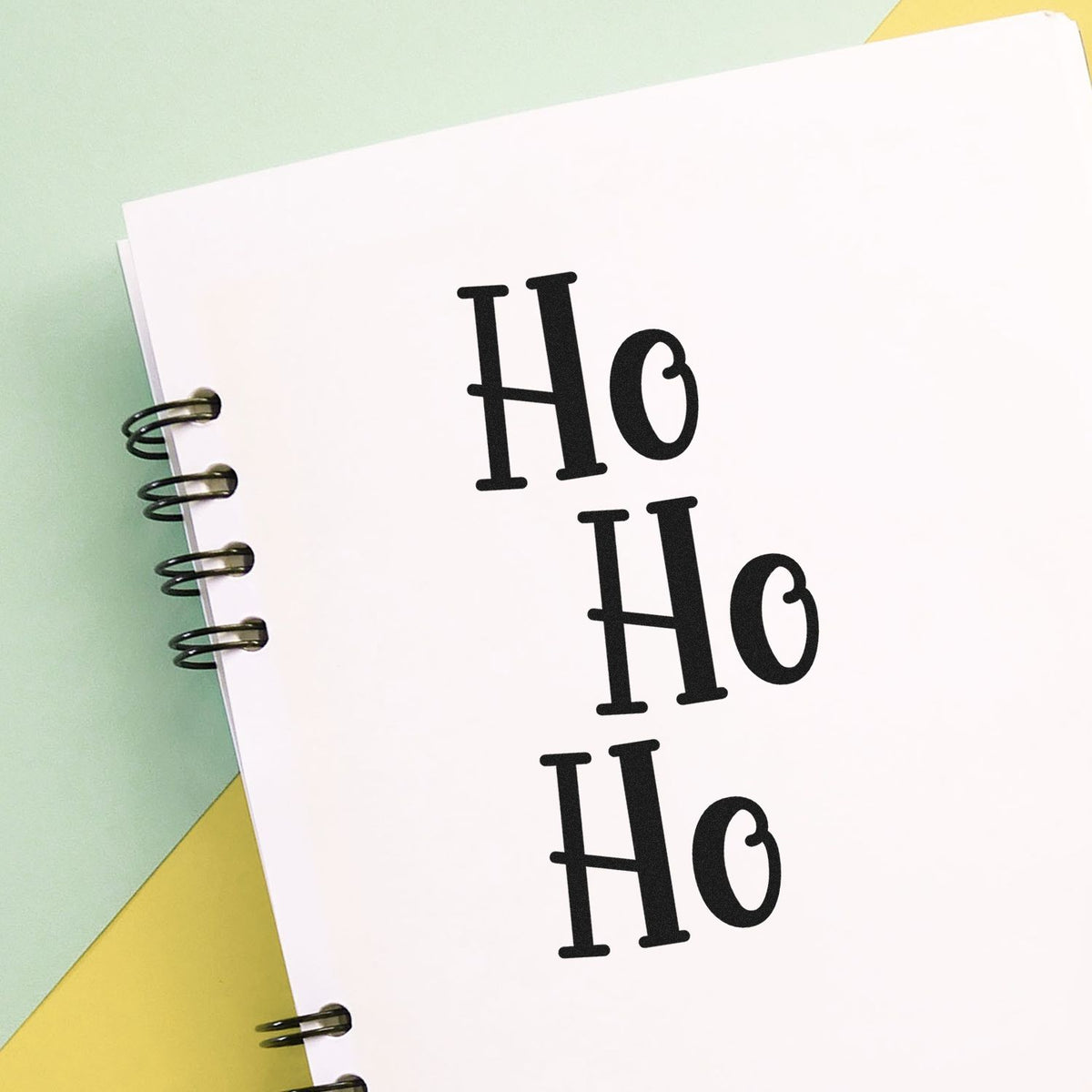 Vintage Pro Three Stacked Ho Words Premium Wooden Stamp imprint stamped in black ink. Three offset rows read "Ho Ho Ho" in tall serif letters.