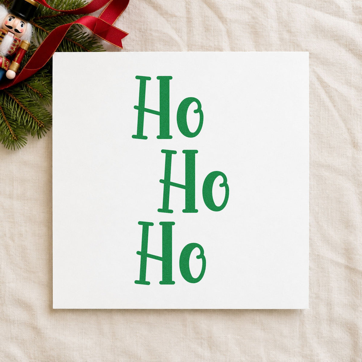 Three Stacked Ho Words craft stamp imprint in green ink on a handmade project, one idea being stacked gift tags.