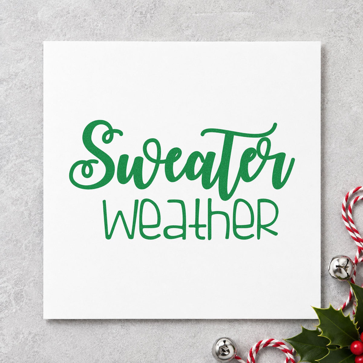 Sweater Weather Script craft stamp imprint in green ink on a handmade project, one idea being yarn skein tags.