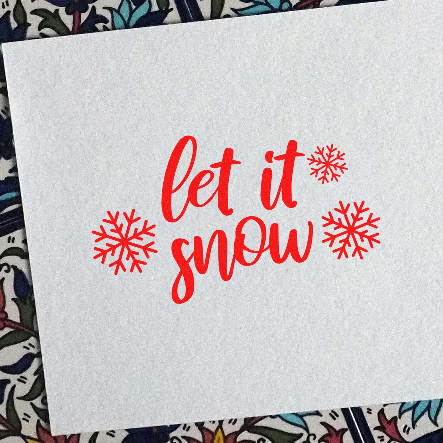 Holiday rubber stamp design with red Let It Snow script and snowflakes for Christmas and winter crafts.