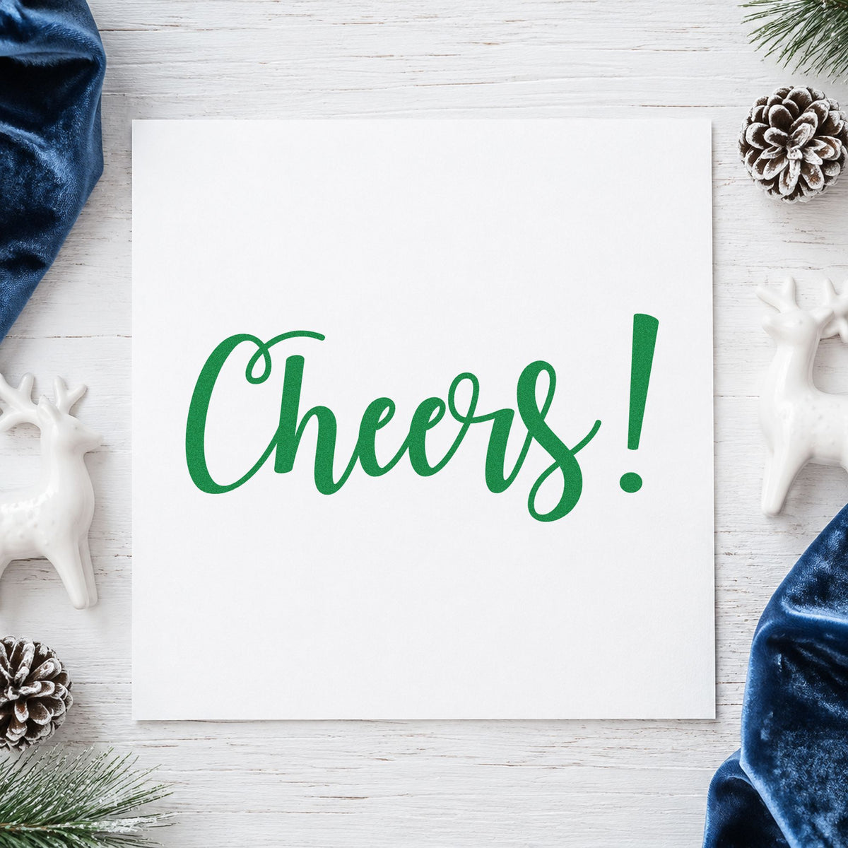 Cheers Flowing Script craft stamp imprint in green ink on a handmade project, one idea being new year place cards.