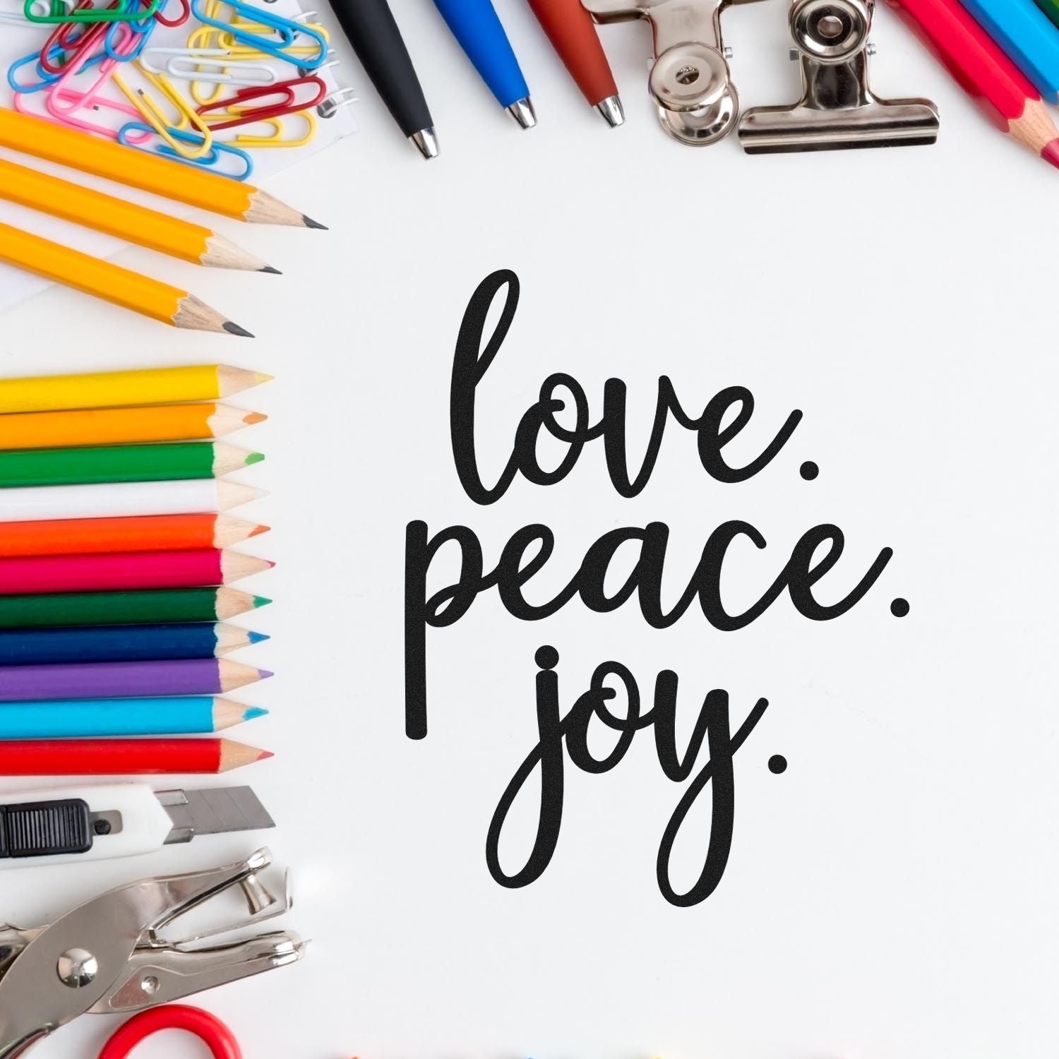 Love Peace Joy rubber stamp design surrounded by colorful stationery, ideal for crafting, journals, and handmade cards.
