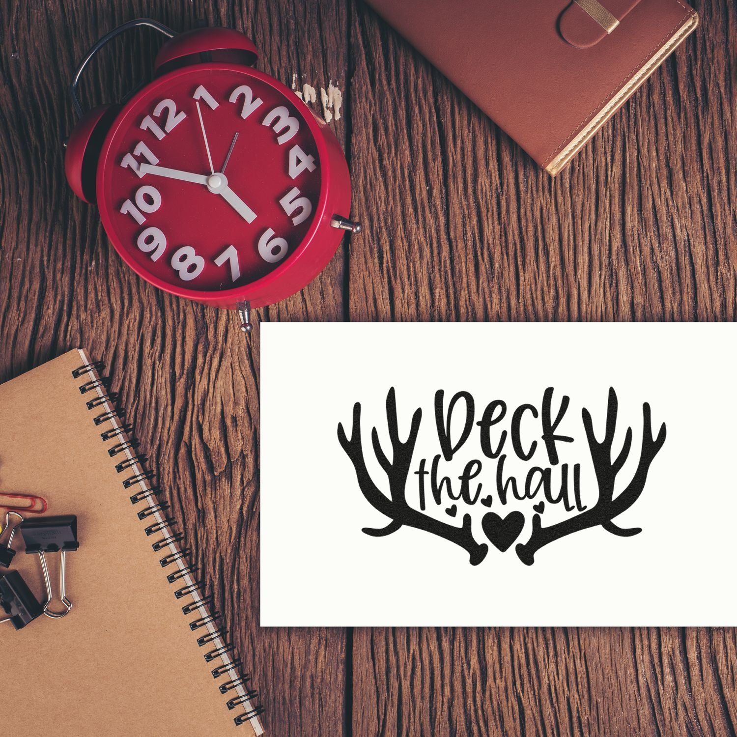 Deck the Hall rubber stamp design for Christmas cards and holiday crafts, shown on a rustic desk.