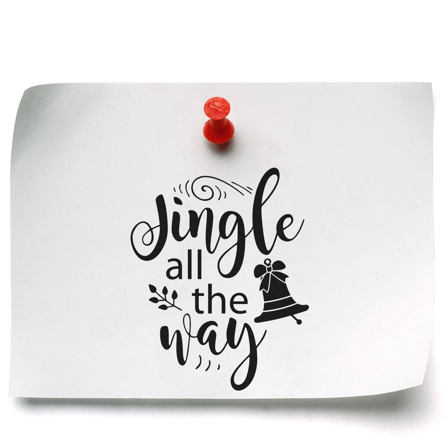 Christmas rubber stamp reading Jingle all the way with bell design, shown on paper pinned with a red pushpin.