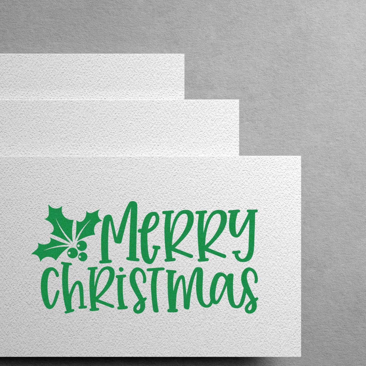 Merry Christmas rubber stamp design with holly on textured paper, ideal for holiday cards, crafts, and custom stamping.