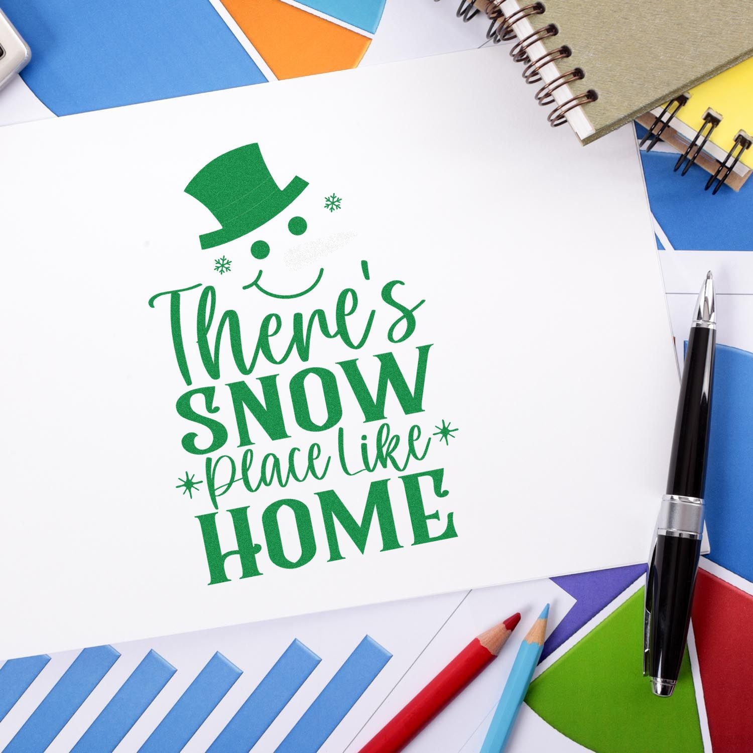 Holiday greeting rubber stamp design with snowman and Theres snow place like home message on paper.