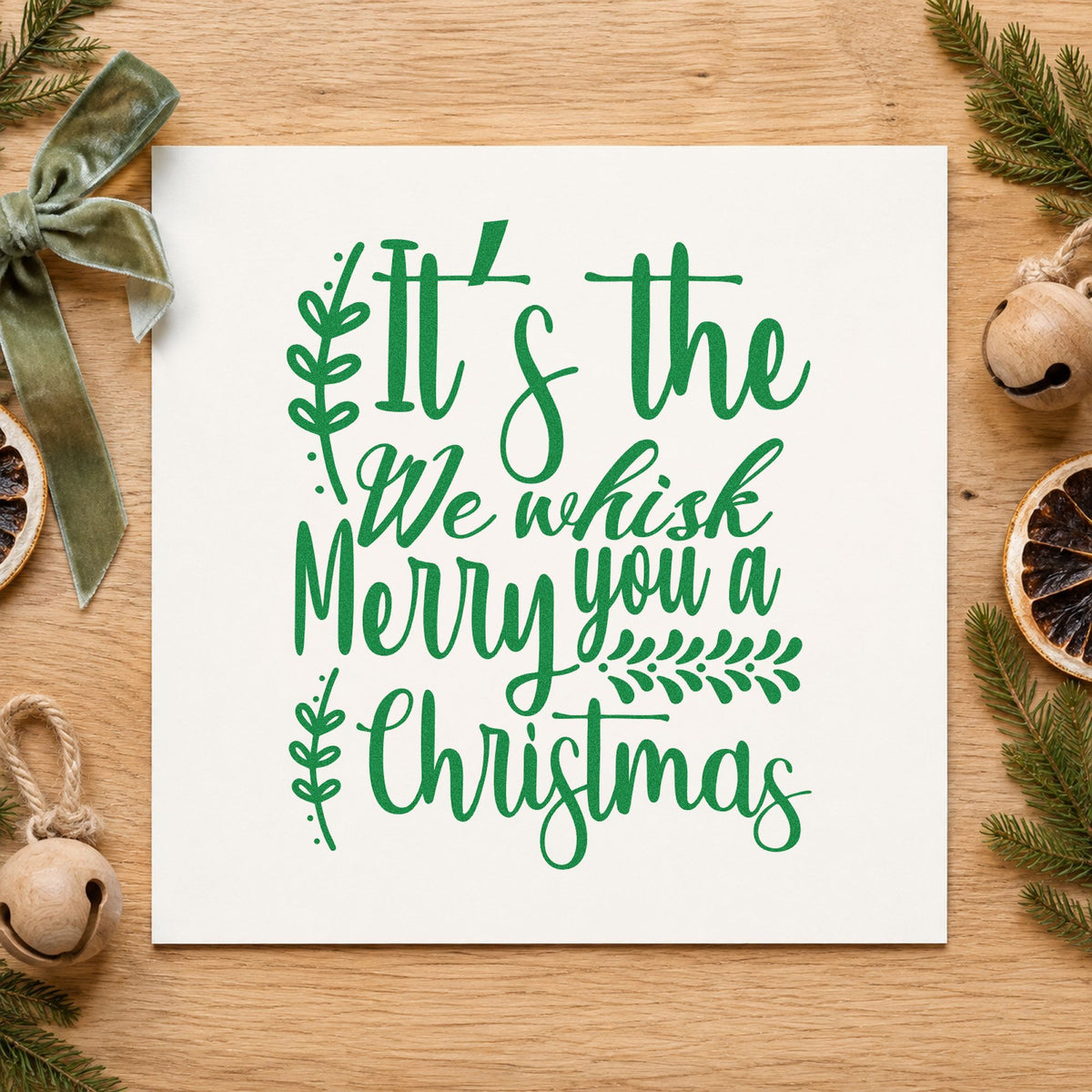 We Whisk Merry Christmas craft stamp imprint in green ink on a handmade project, one idea being bake sale placards.