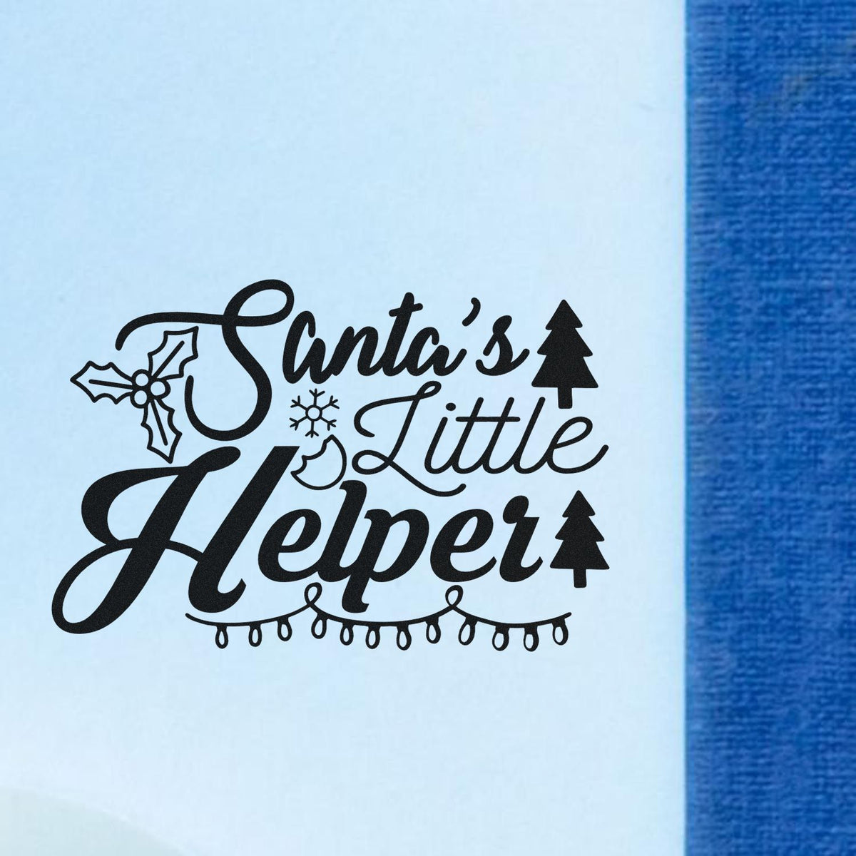 Santa's Little Helper Lights Holly Premium Wooden Stamp - Vintage Pro imprint stamped in black ink. "Santa's Little Helper" is decorated with holly, snowflakes, trees, and hanging lights.