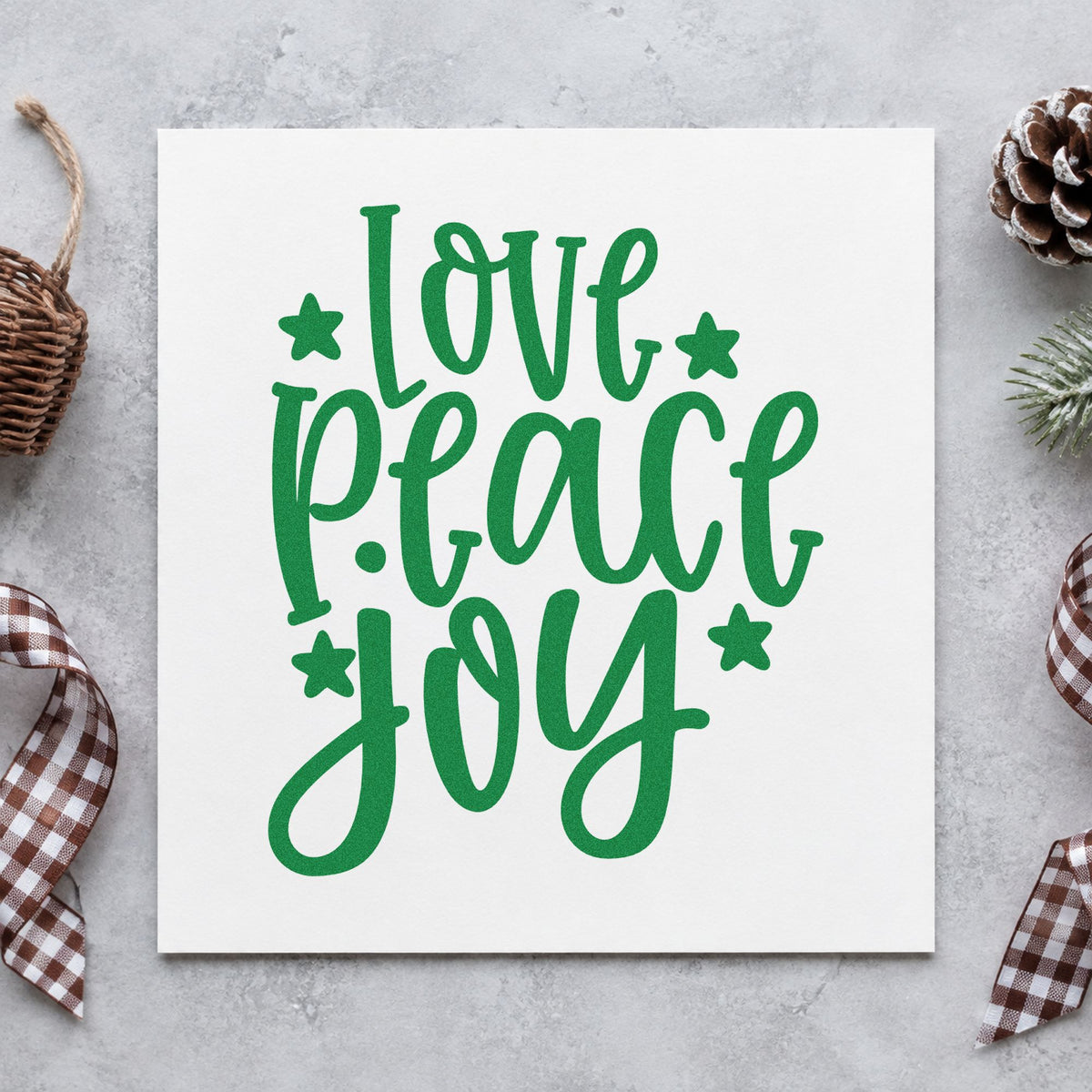 Love Peace Joy Stars craft stamp imprint in green ink on a handmade project, one idea being bookmark strip tags.