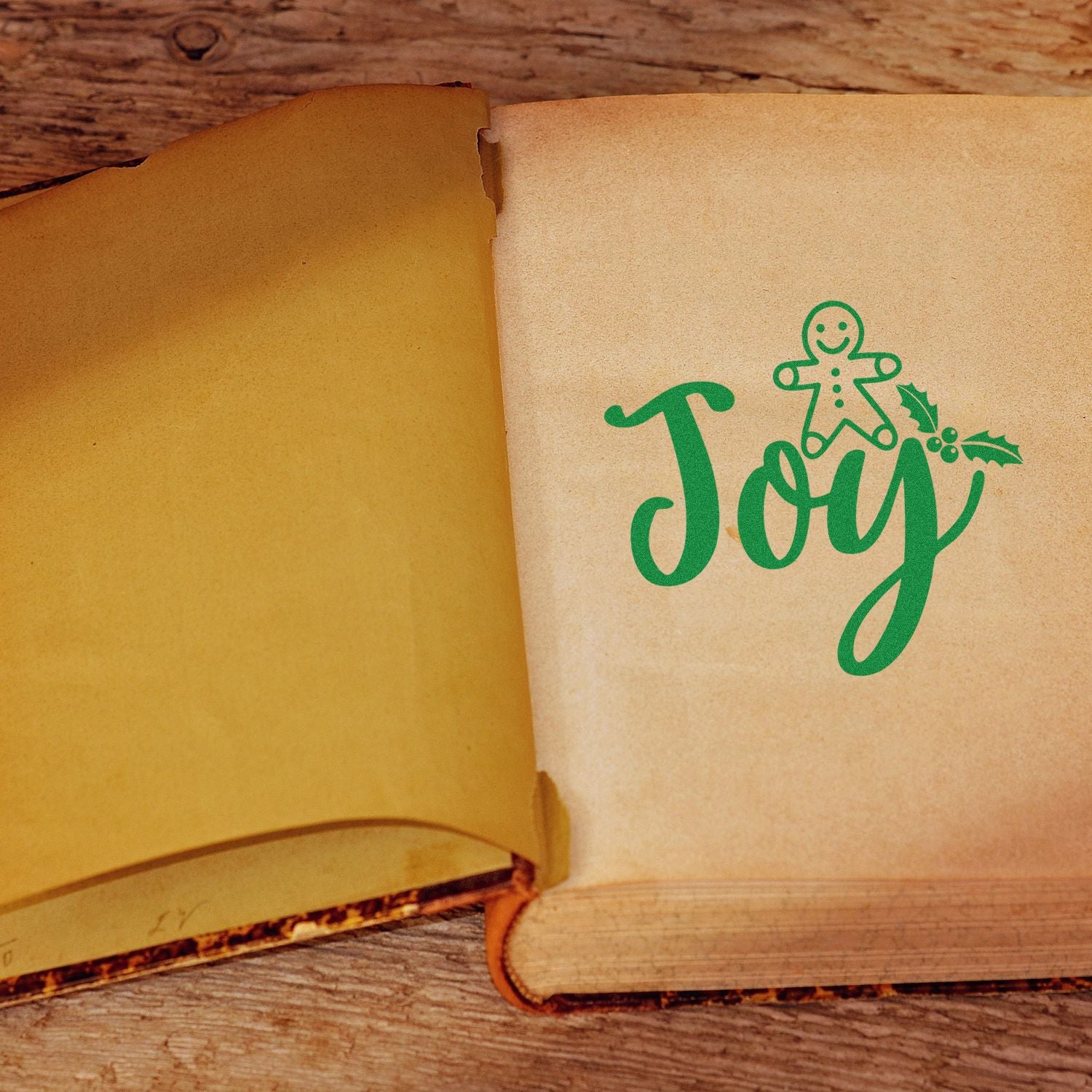 Christmas Joy rubber stamp imprint with gingerbread man and holly on a vintage book page