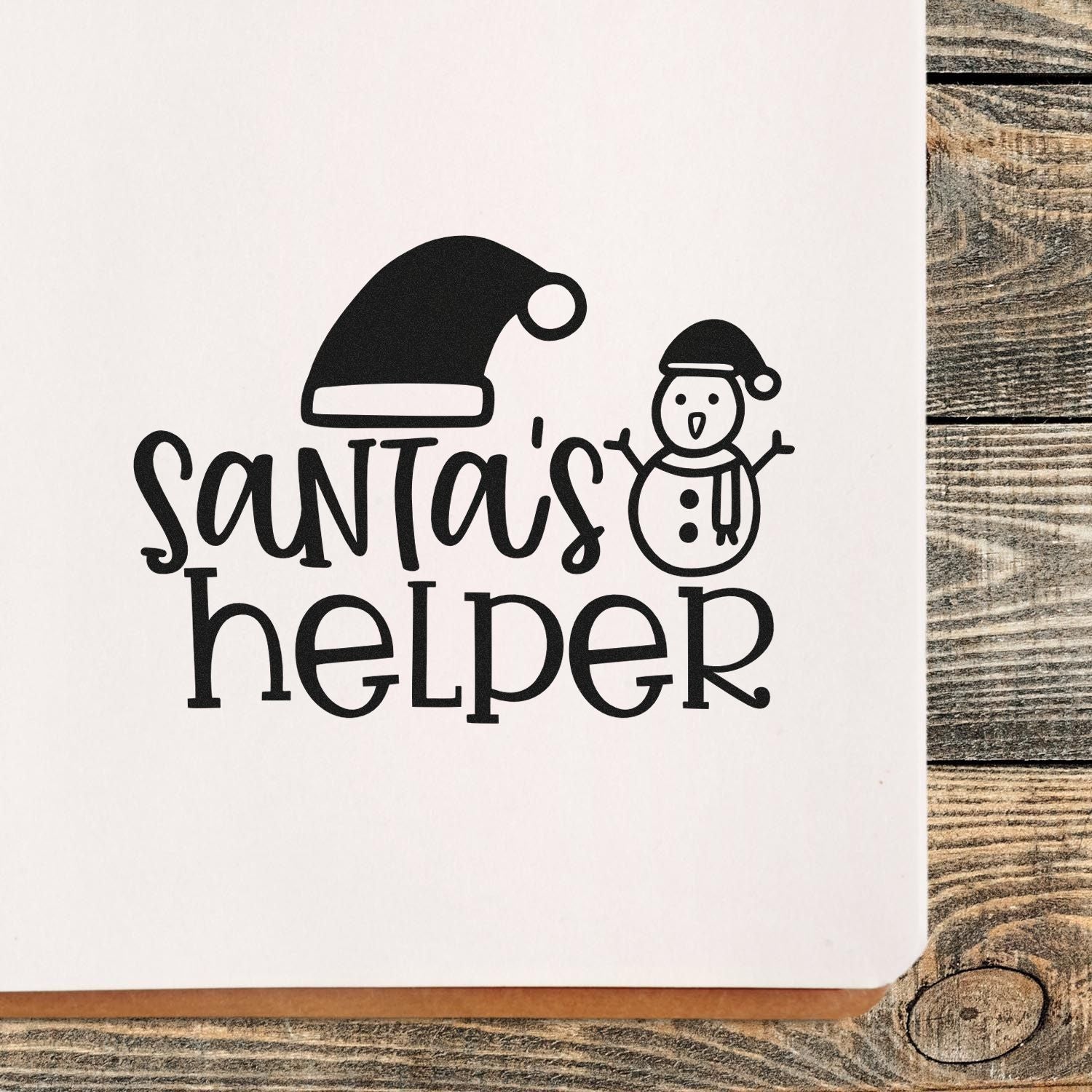 Santas helper rubber stamp design with Santa hat and snowman, festive holiday stamp for cards, crafts, and packaging.