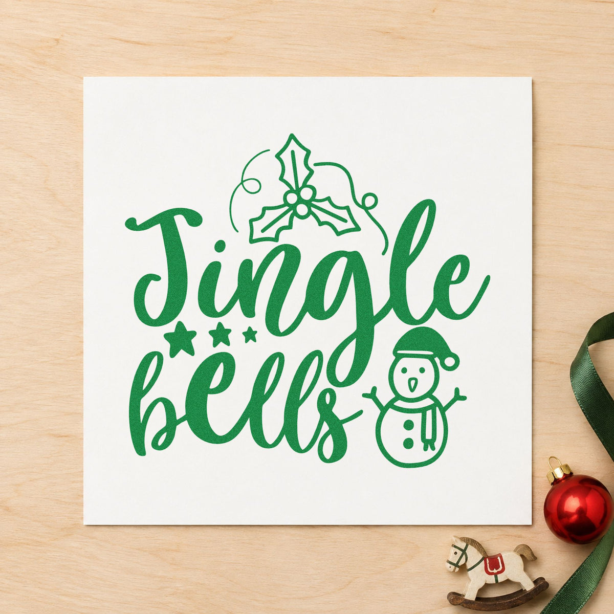 Jingle Bells Holly Snowman craft stamp imprint in green ink on a handmade project, one idea being sing along cards.