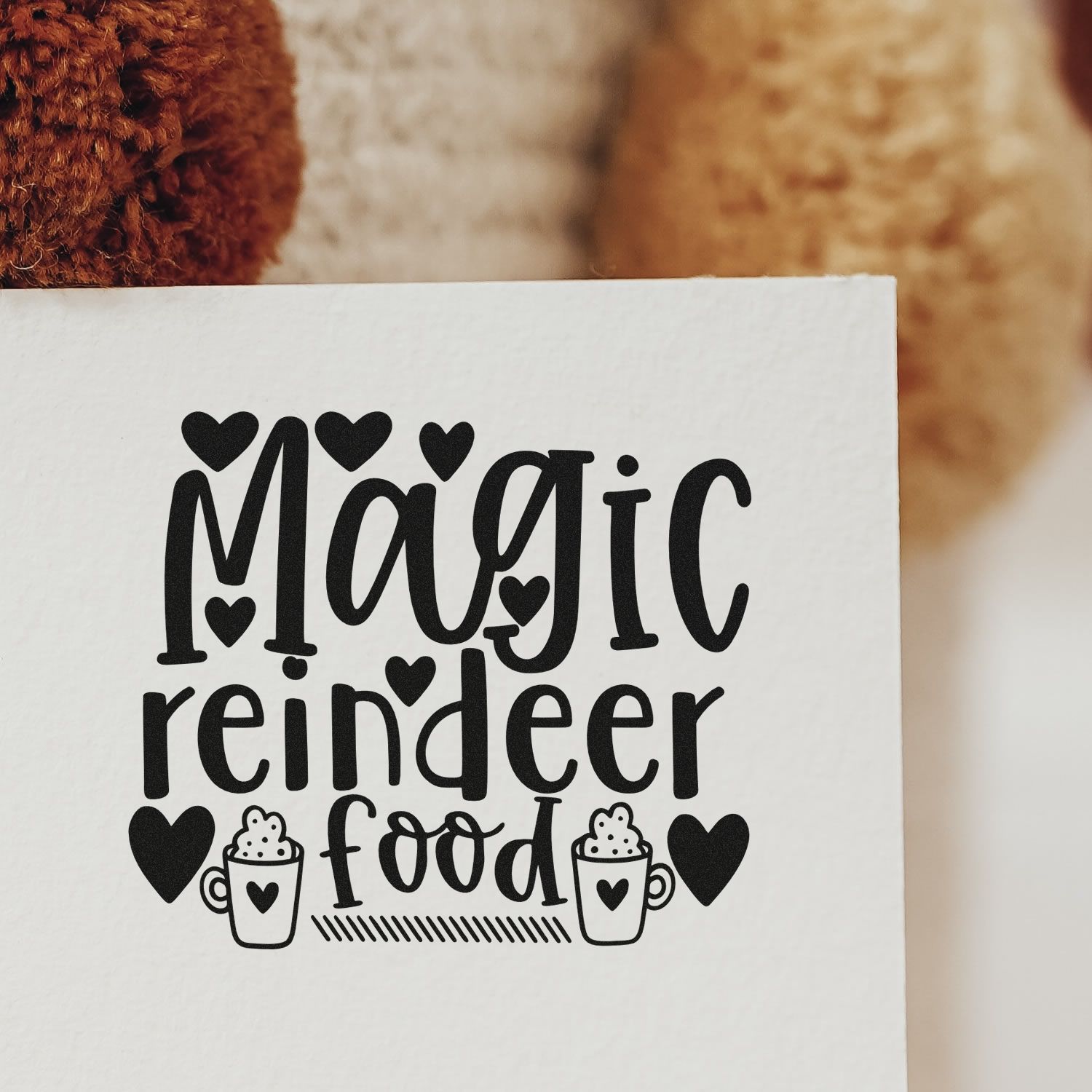 Magic reindeer food rubber stamp design with hearts and cocoa mugs for Christmas gift tags and holiday crafts.