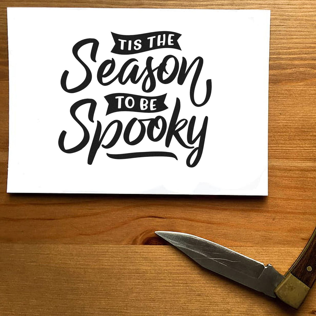 Season To Be Spooky Stamp - Premium Vintage Pro Wooden imprint stamped in blue ink. The phrase "Tis the season to be spooky" combines large script with small ribbon banners.