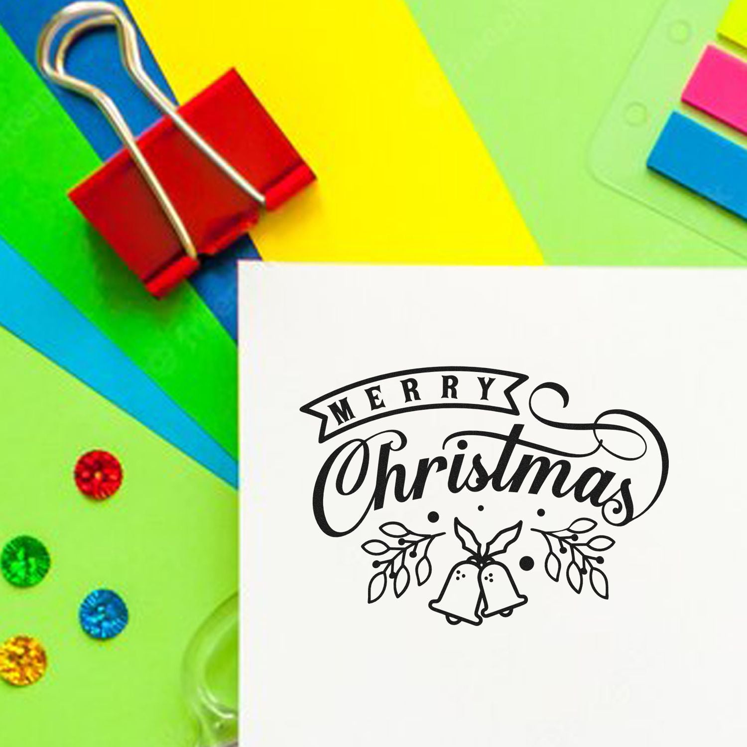 Merry Christmas rubber stamp design on paper with colorful stationery for holiday card making and craft projects.
