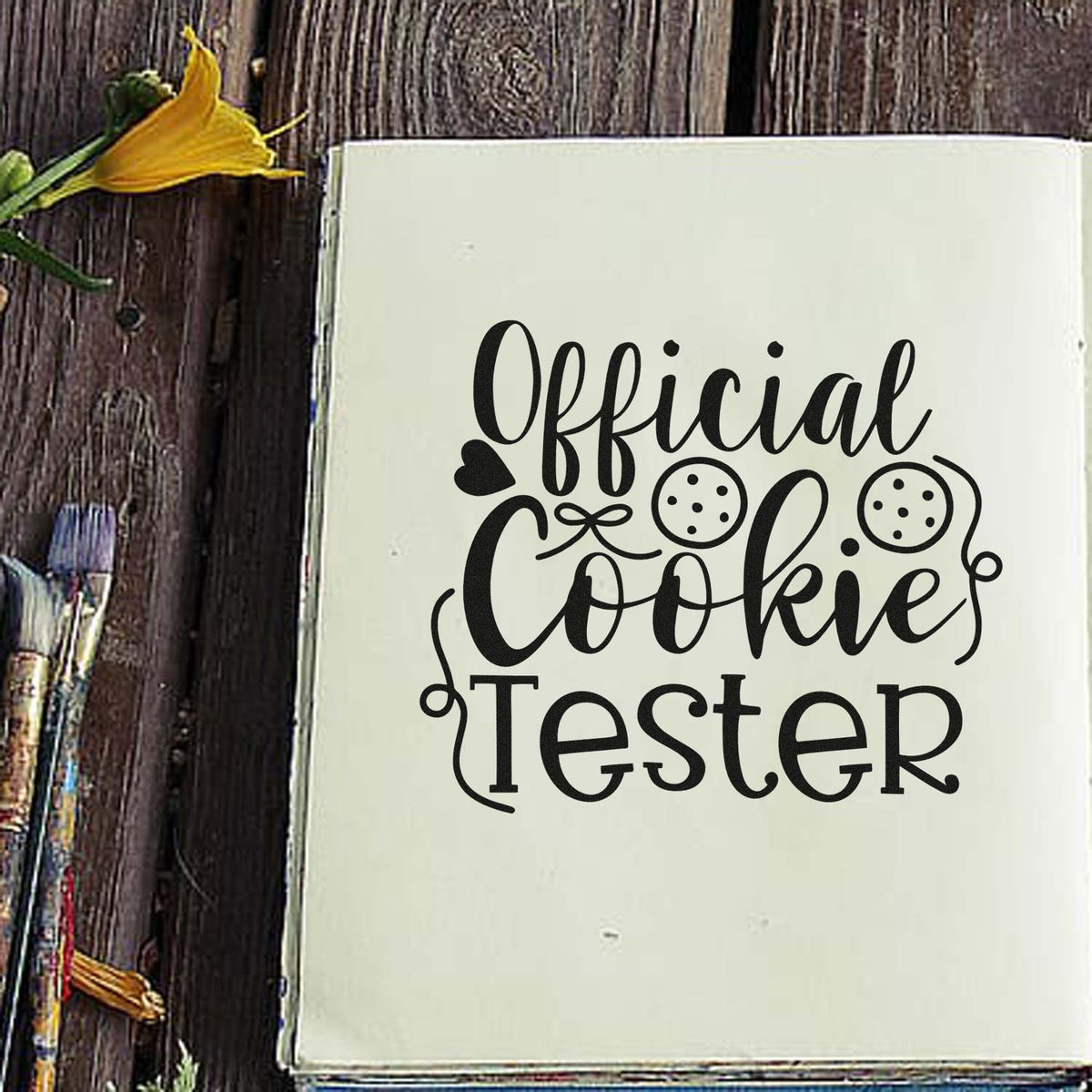 Official Cookie Tester Script Wood Handle Stamp imprint stamped in black ink. The words "Official cookie tester" include two round cookies and a small heart.