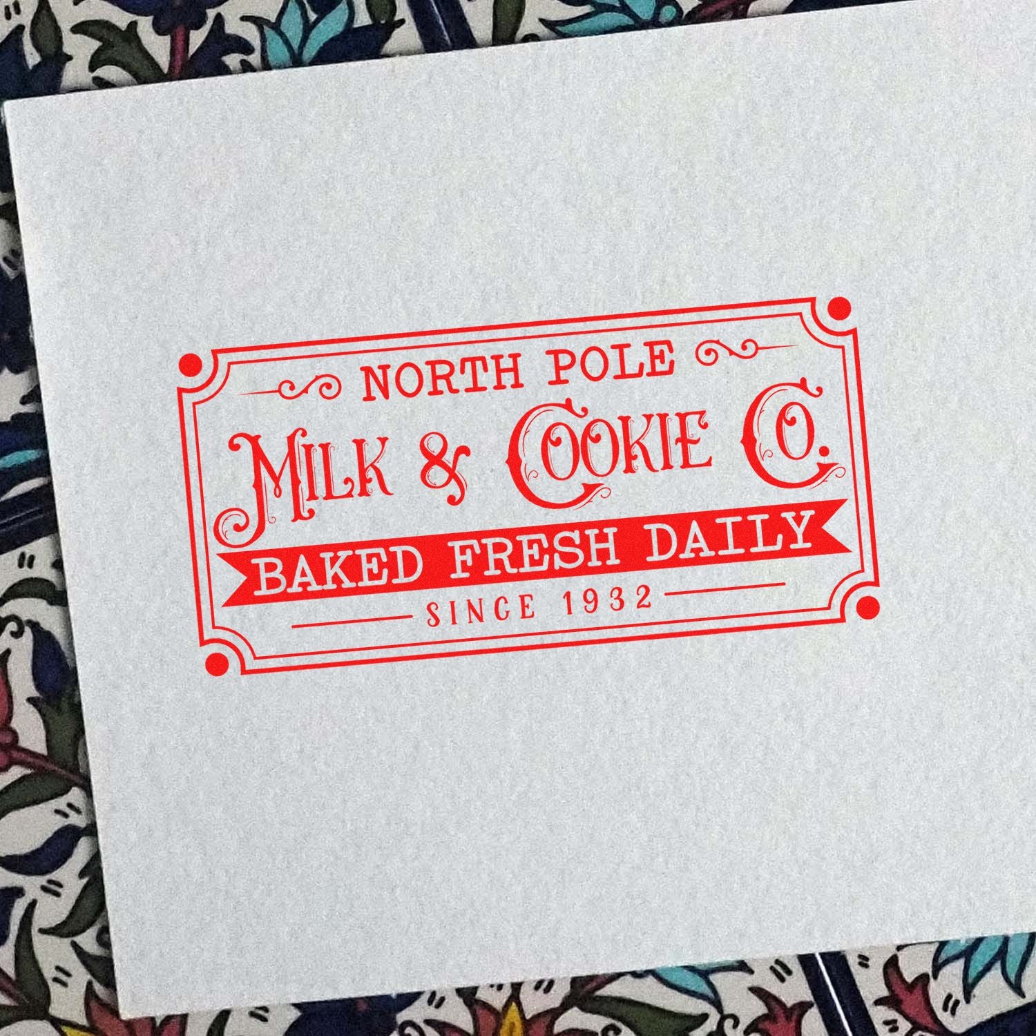 Custom rubber stamp impression for North Pole Milk & Cookie Co., featuring vintage bakery branding and Baked Fresh Daily Since 1932.