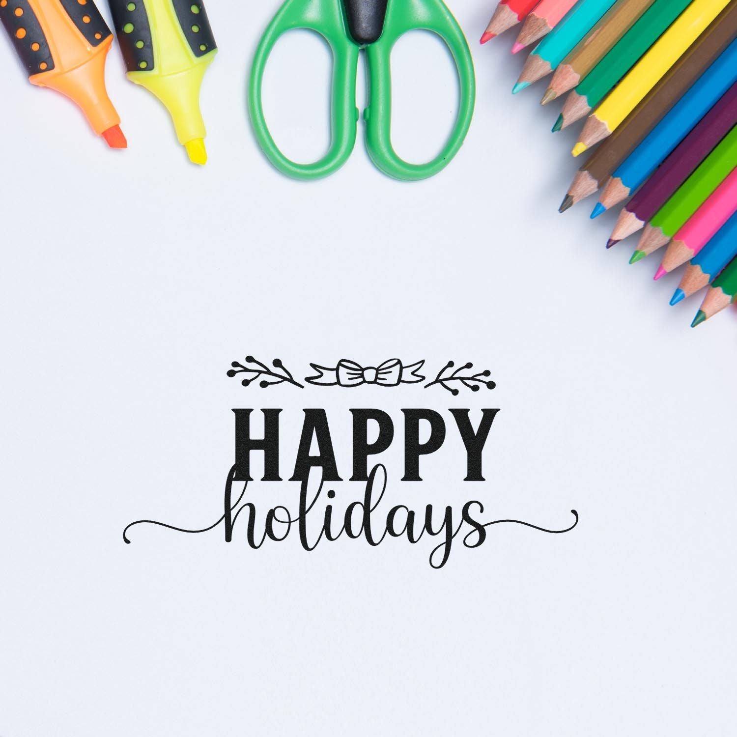 Happy Holidays rubber stamp impression on paper with pencils and scissors, ideal for festive card making and crafts.