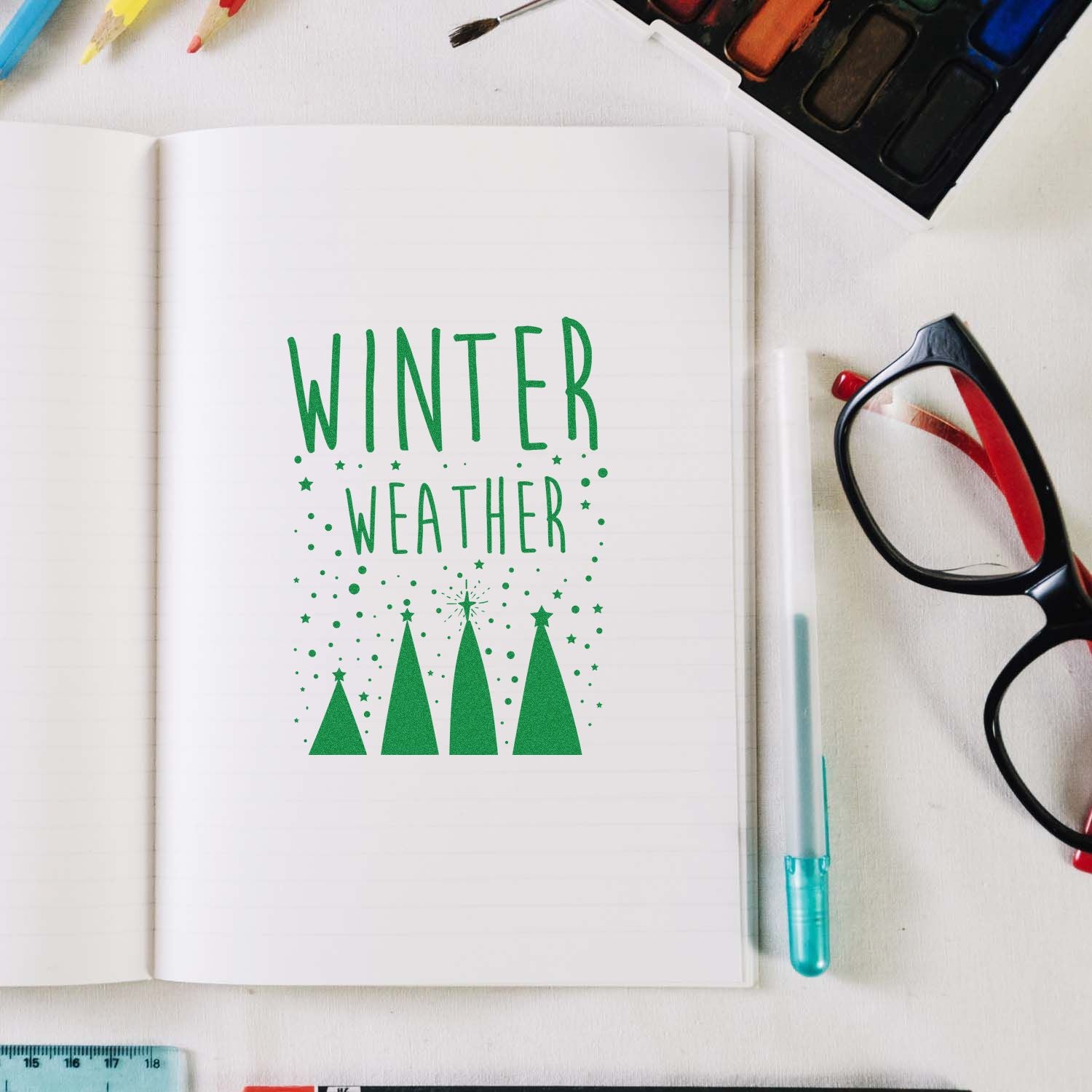 Winter Weather rubber stamp impression in green on a notebook page, ideal for seasonal card making and crafting.
