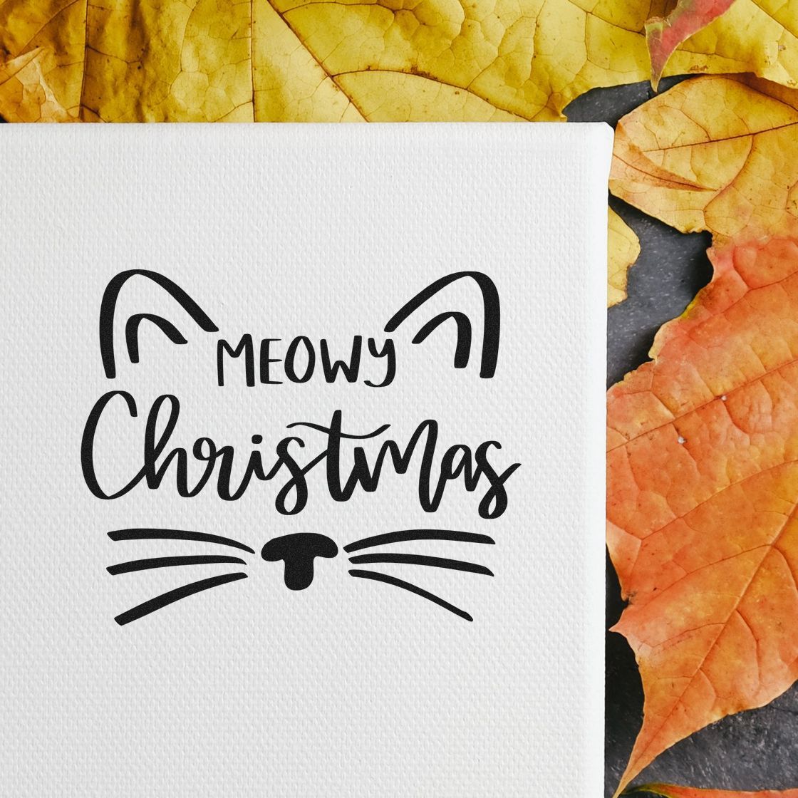 Meowy Christmas cat rubber stamp on white card for festive holiday card making, with cat ears, whiskers and lettering.