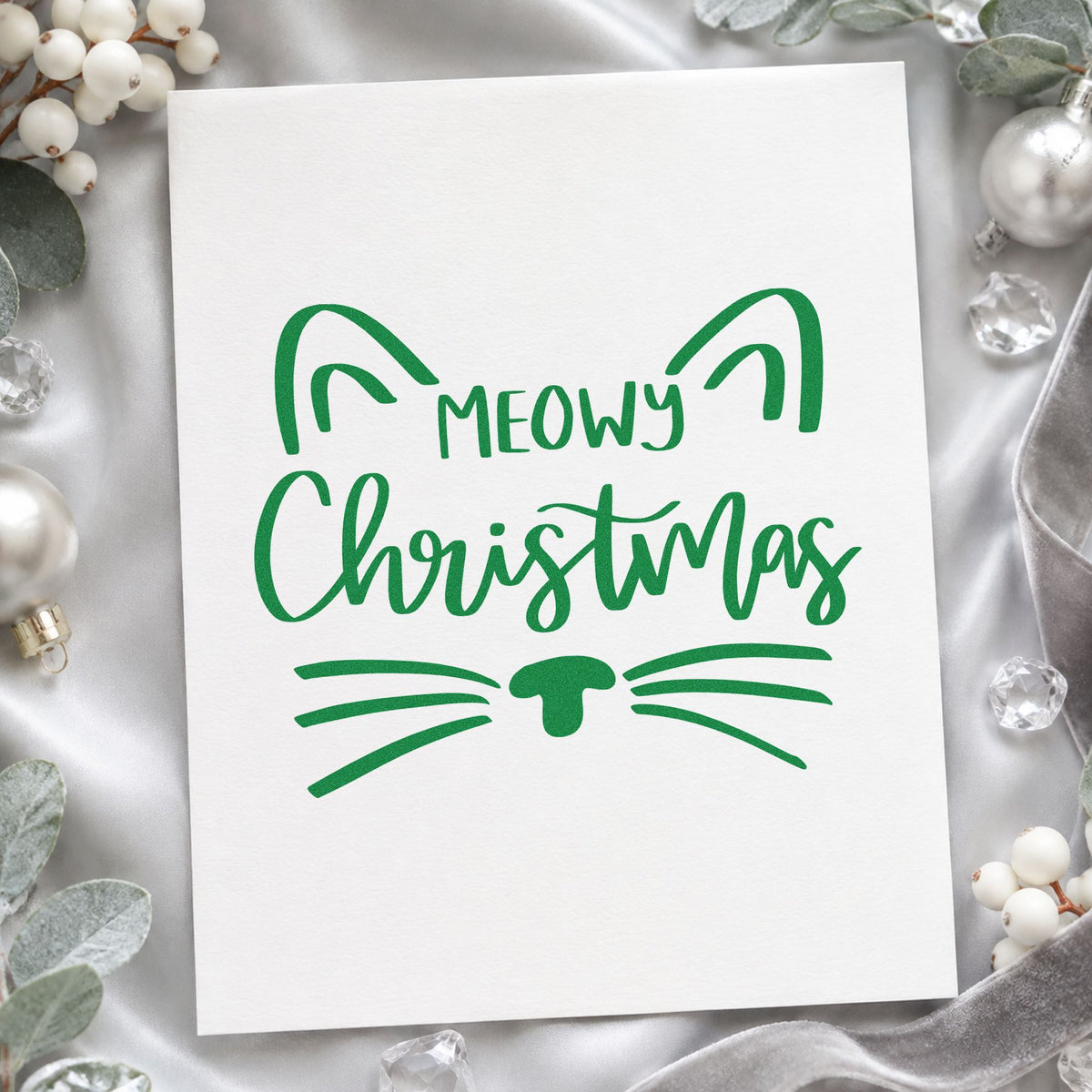 Meowy Christmas Cat Face craft stamp imprint in green ink on a handmade project, one idea being catnip bag tags.