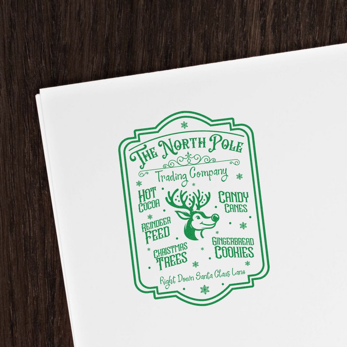 Christmas rubber stamp design for The North Pole Trading Company with reindeer, candy canes, cocoa, trees, and cookies.