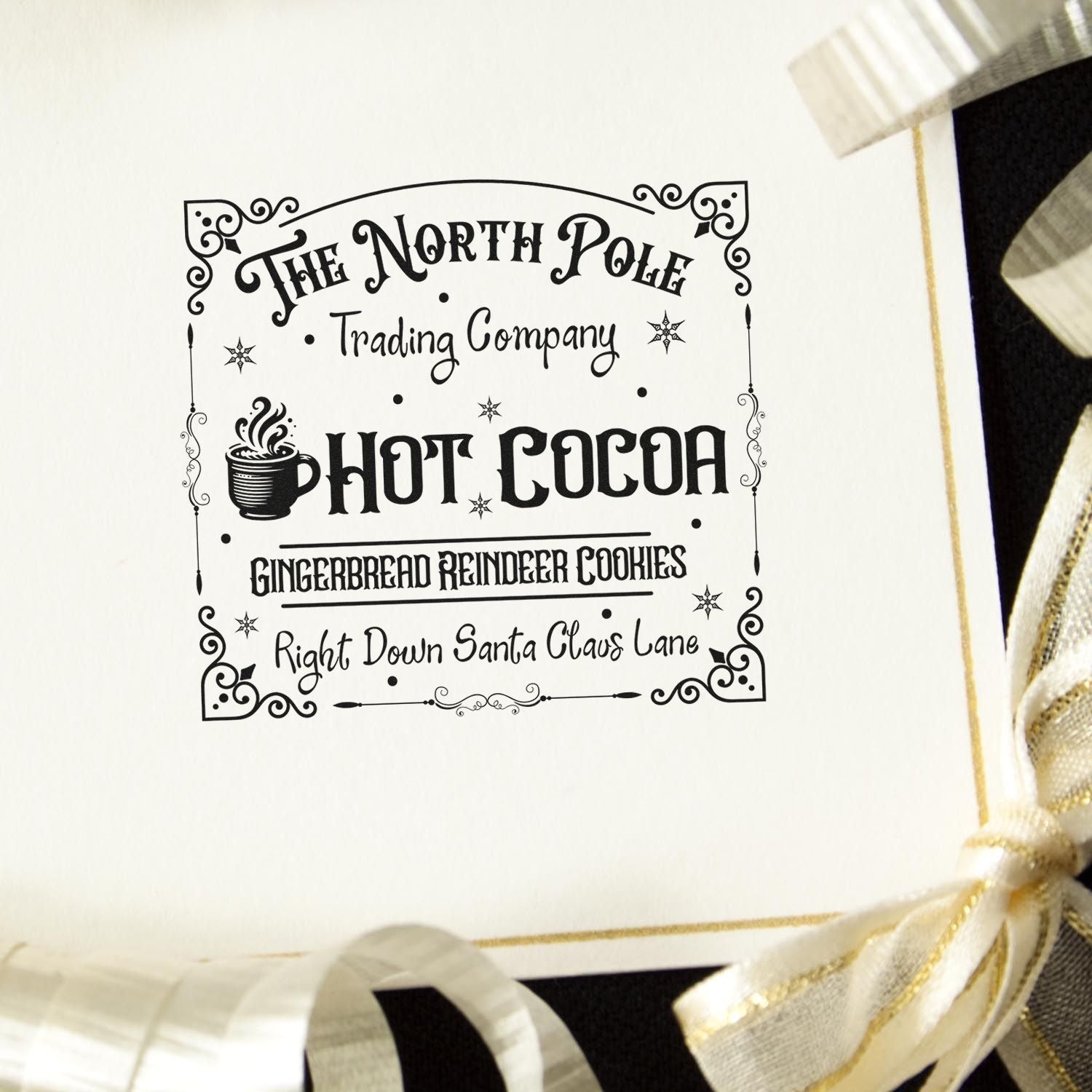 Custom Christmas rubber stamp for holiday packaging with North Pole Trading Company, hot cocoa, and gingerbread reindeer cookies design.