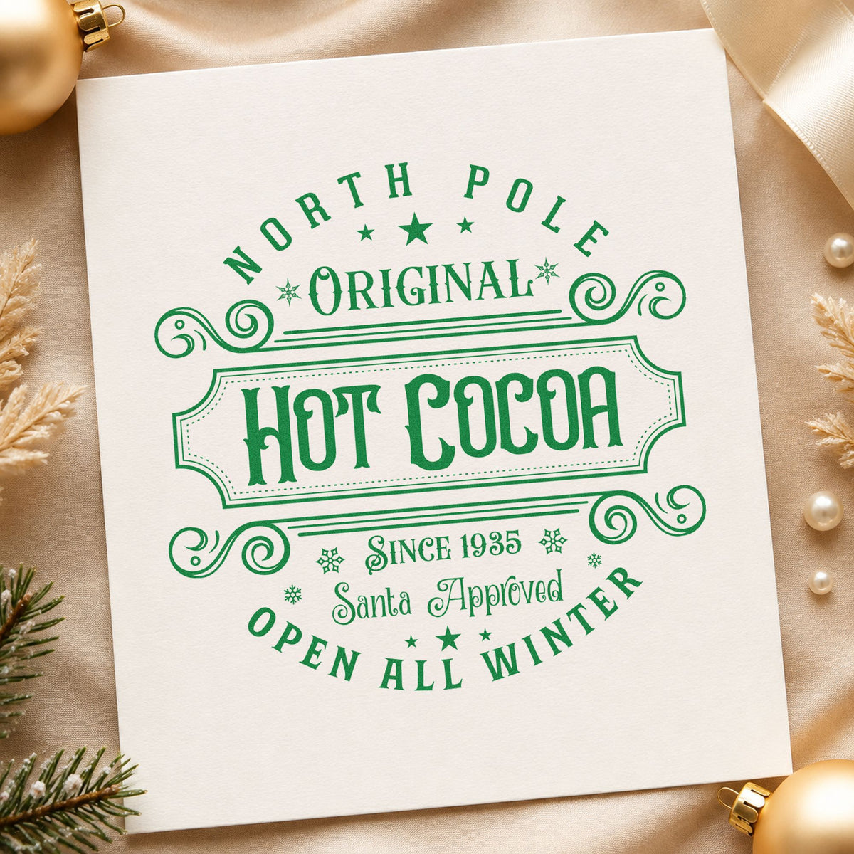 North Pole Original Hot Cocoa craft stamp imprinted in green ink on paper, a design suited to framed shop ledge.