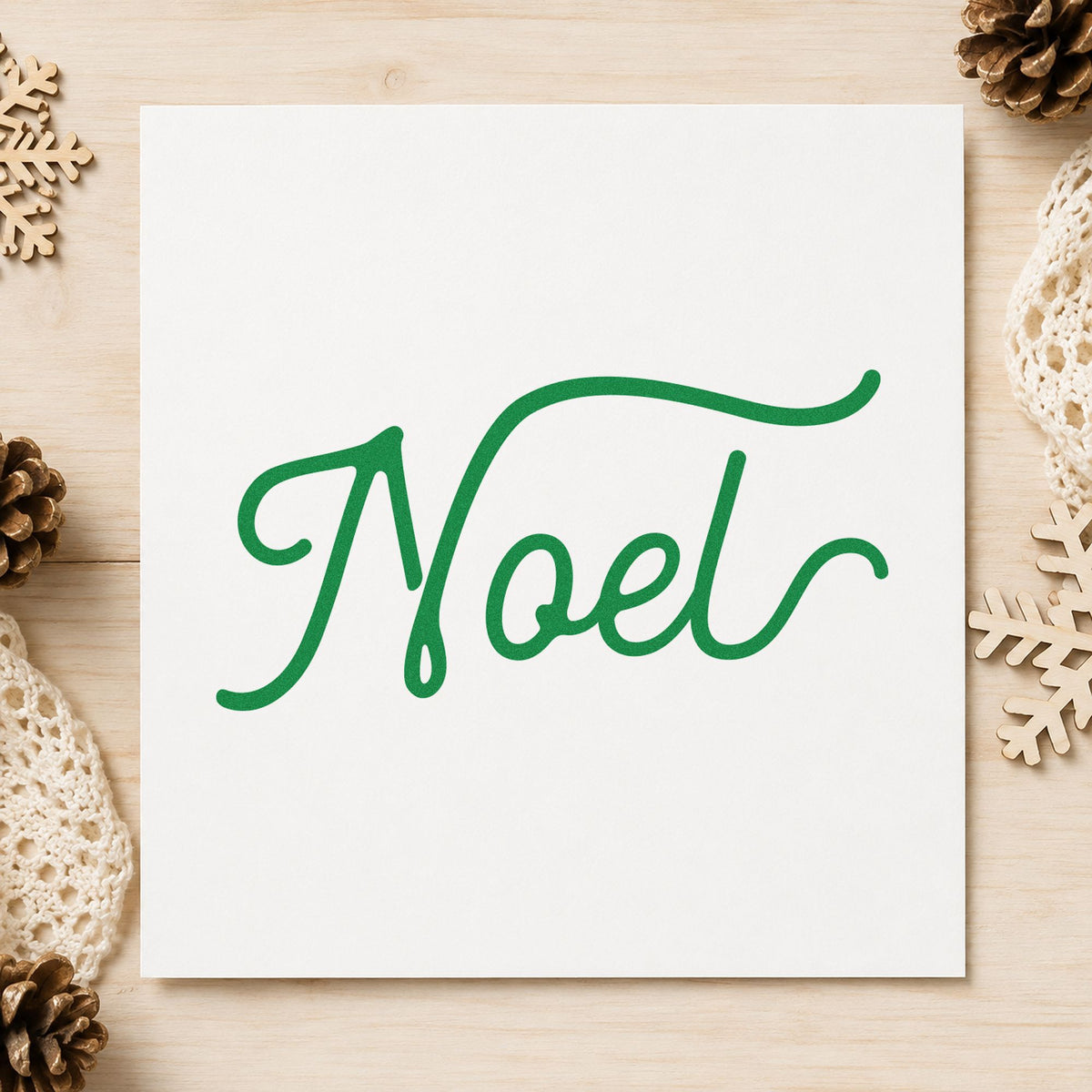 Noel Flowing Script craft stamp imprinted in green ink on paper, a design suited to framed long console.