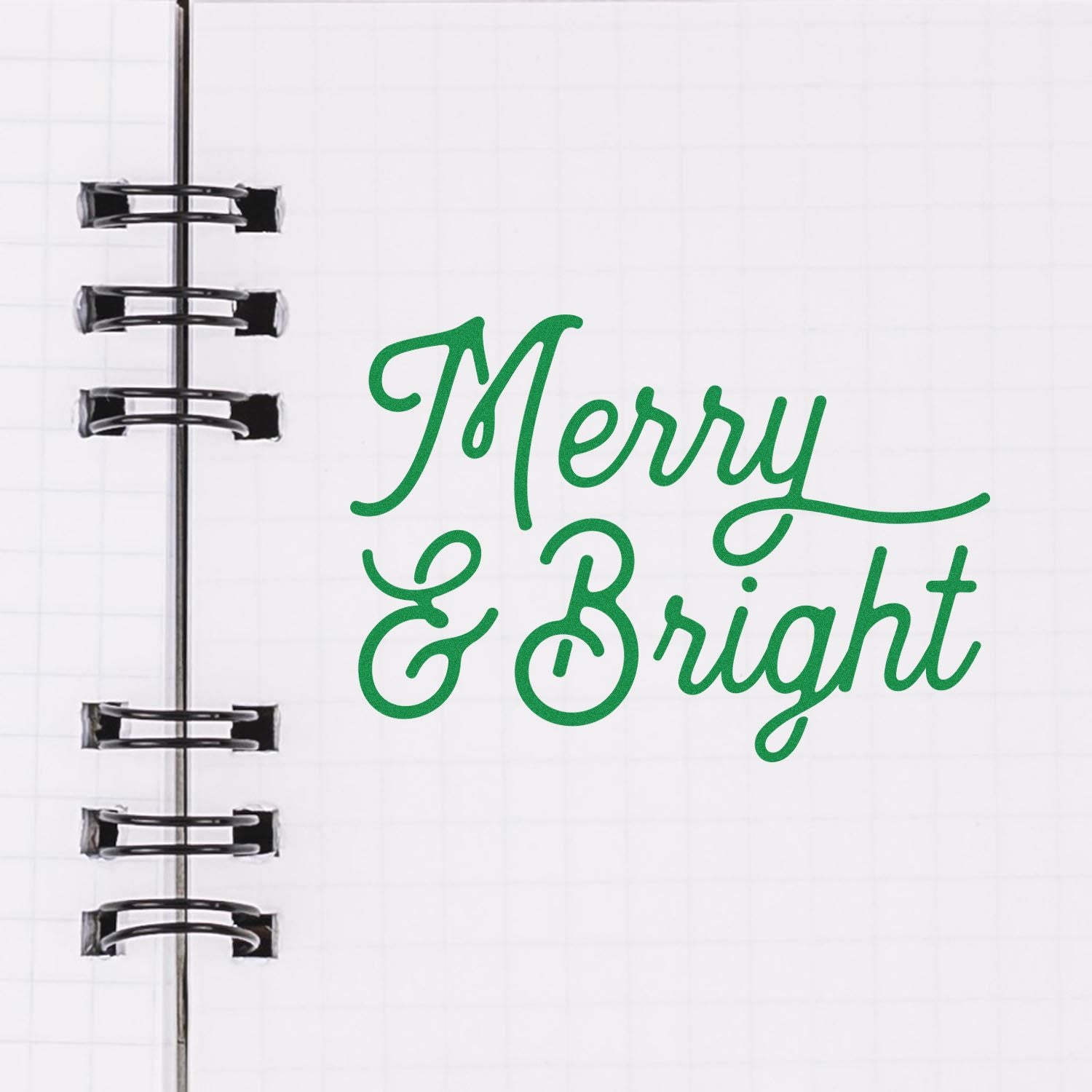 Merry & Bright green script rubber stamp design for holiday cards, shown on a spiral notebook page.