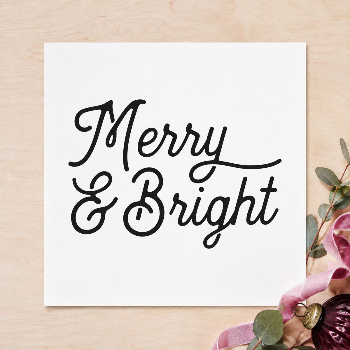 Merry And Bright Script craft stamp imprint in black ink on a handmade project, one idea being flourished gift tags.