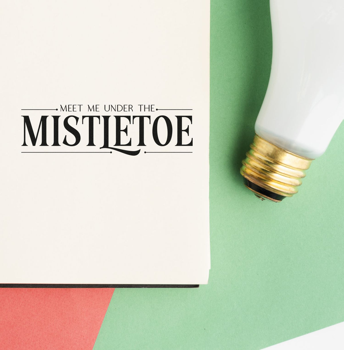 Meet Me Under The Mistletoe Serif Lettering Premium Wooden Stamp - Vintage Pro imprint stamped in black ink. The words "Meet me under the mistletoe" appear in decorative serif lettering between thin rules.