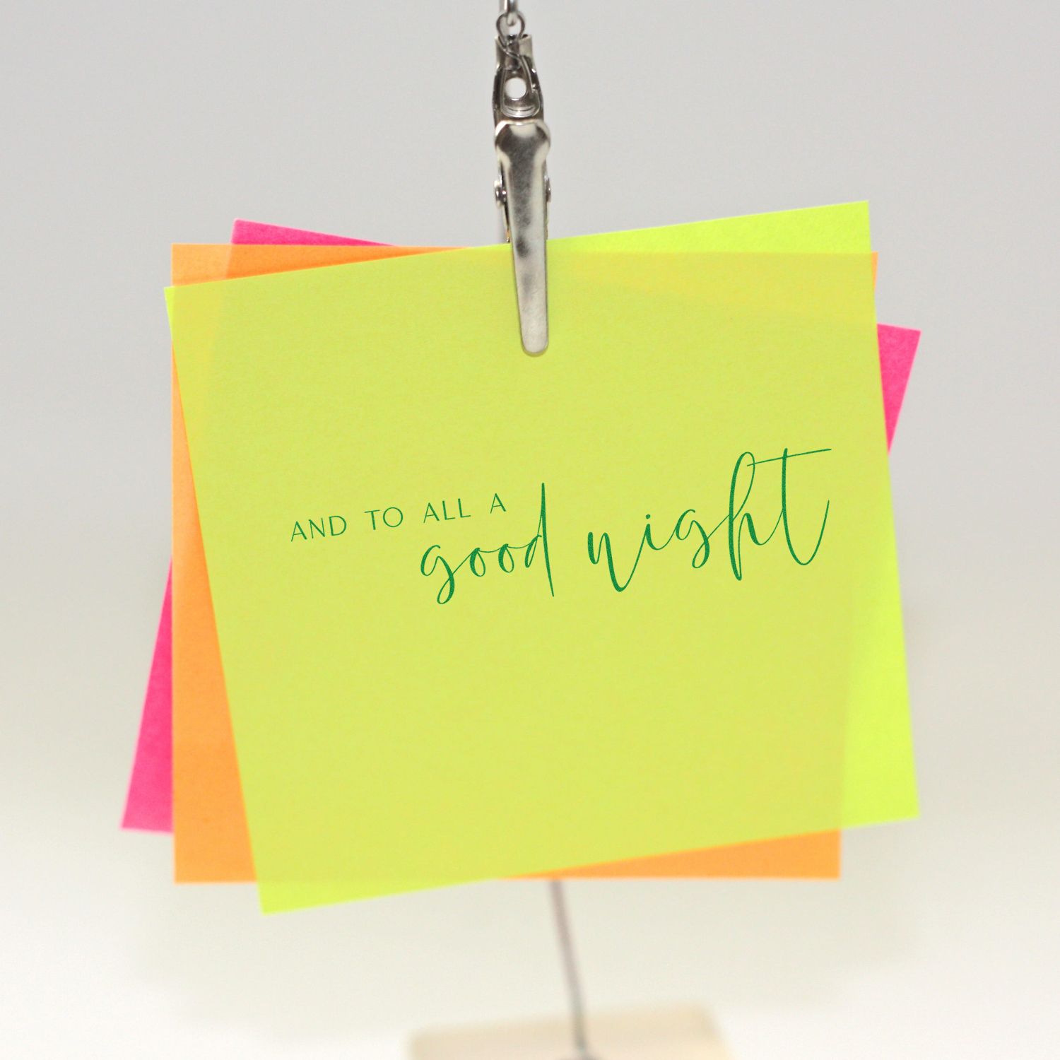 Holiday rubber stamp reading And to All a Good Night on neon sticky notes, ideal for Christmas cards and crafts.