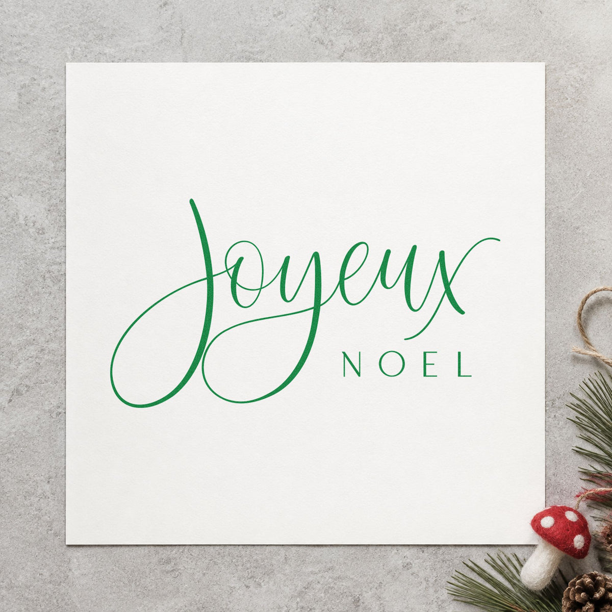 Joyeux Noel Fine Script craft stamp in green ink on cardstock, an easy option for language album page.