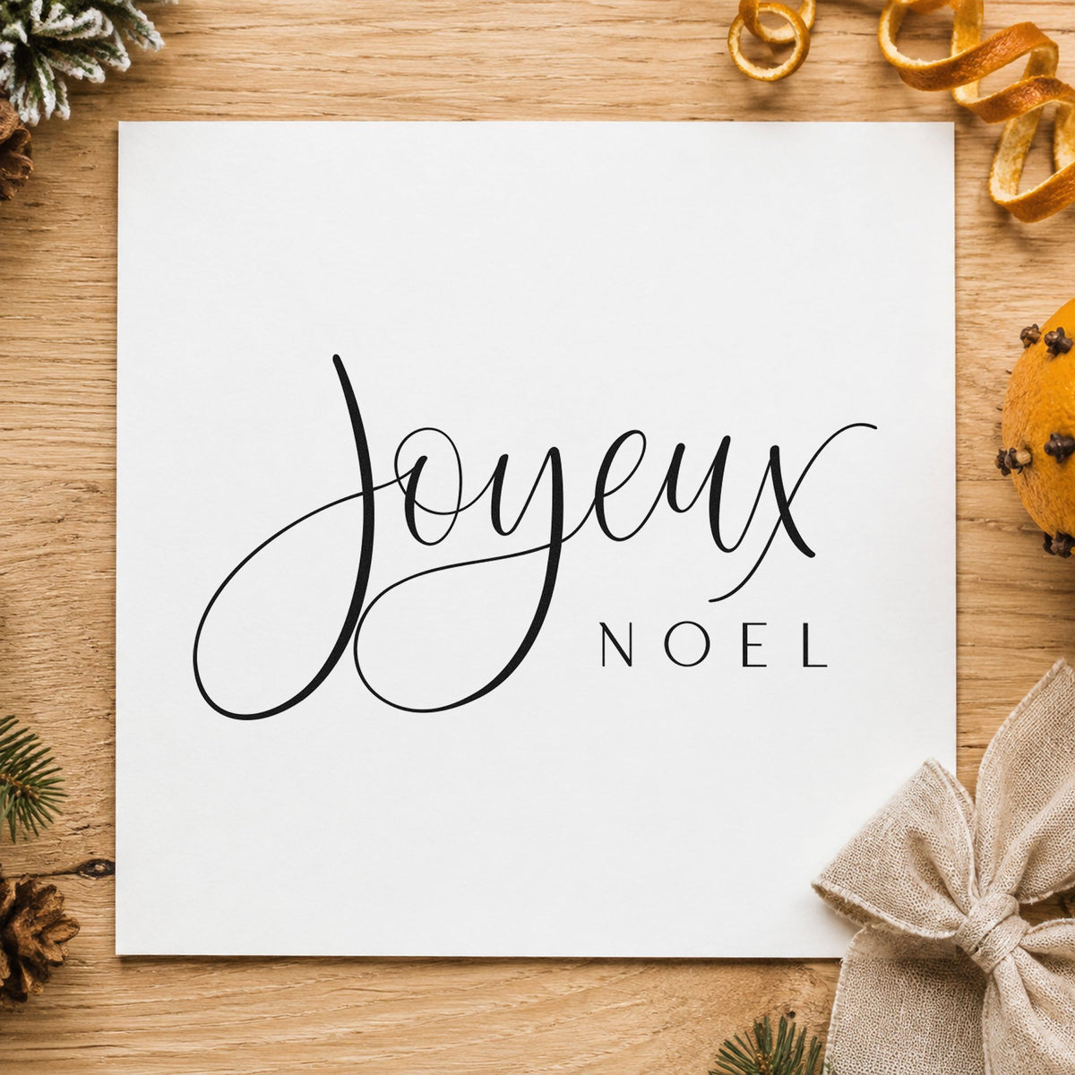Joyeux Noel Fine Script craft stamp imprint in black ink on a handmade project, one idea being import goods tags.