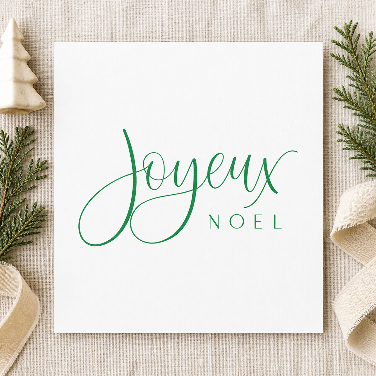 Joyeux Noel Fine Script craft stamp imprinted in green ink on paper, a design suited to framed bistro ledge.