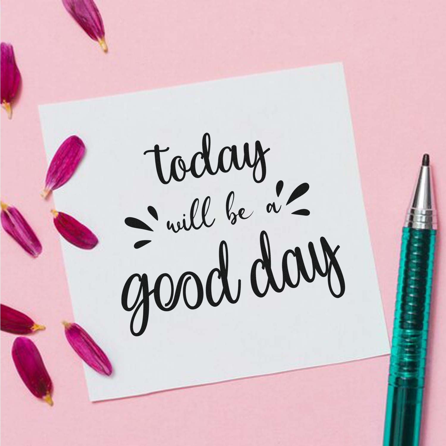 Motivational today will be a good day rubber stamp design on white card with pink petals and pen on a pastel pink background.